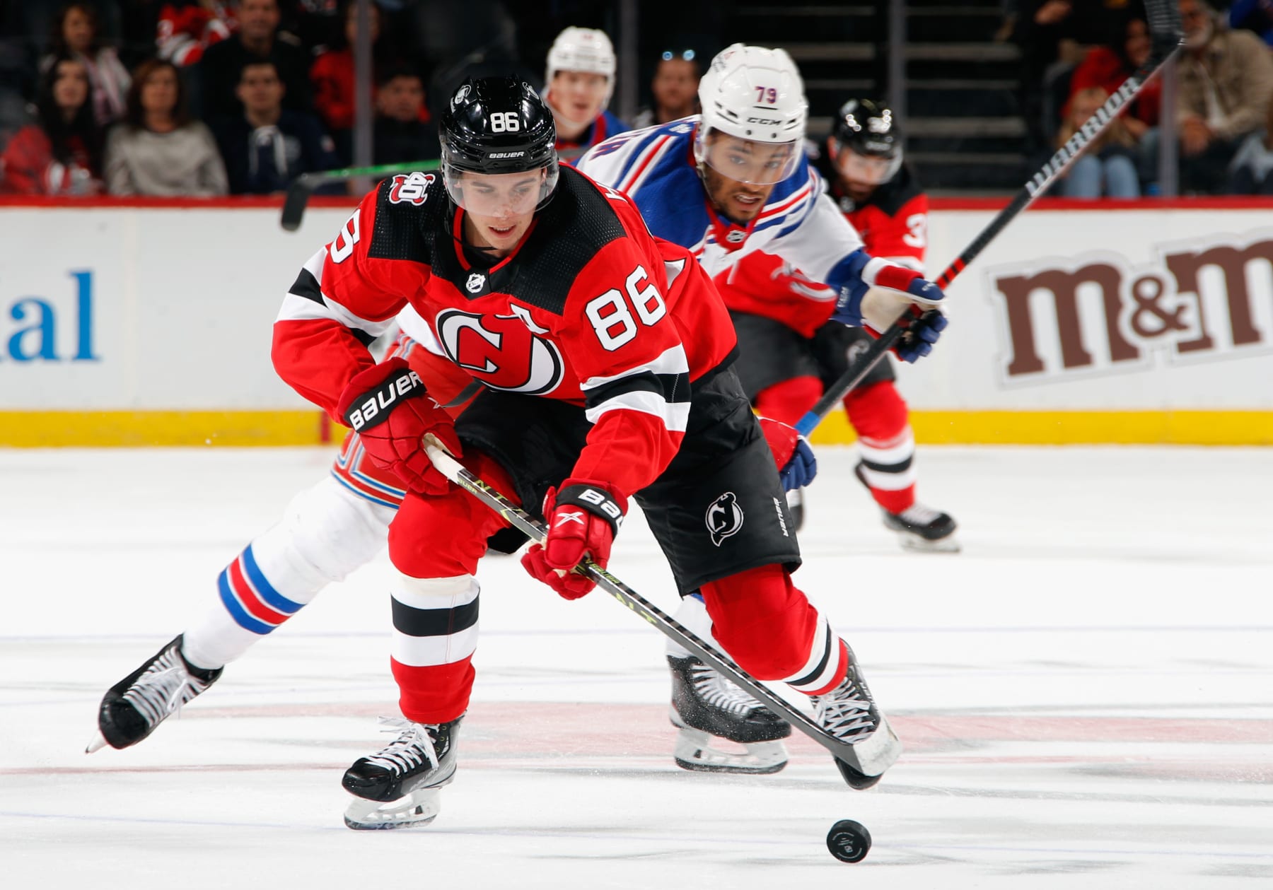 NEWARK, NEW JERSEY - SEPTEMBER 30: K'Andre Miller #79 of the New York Rangers chases Jack Hughes #86 of the New Jersey Devils during the second period at the Prudential Center on September 30, 2022 in Newark, New Jersey. (Photo by Bruce Bennett/Getty Images)