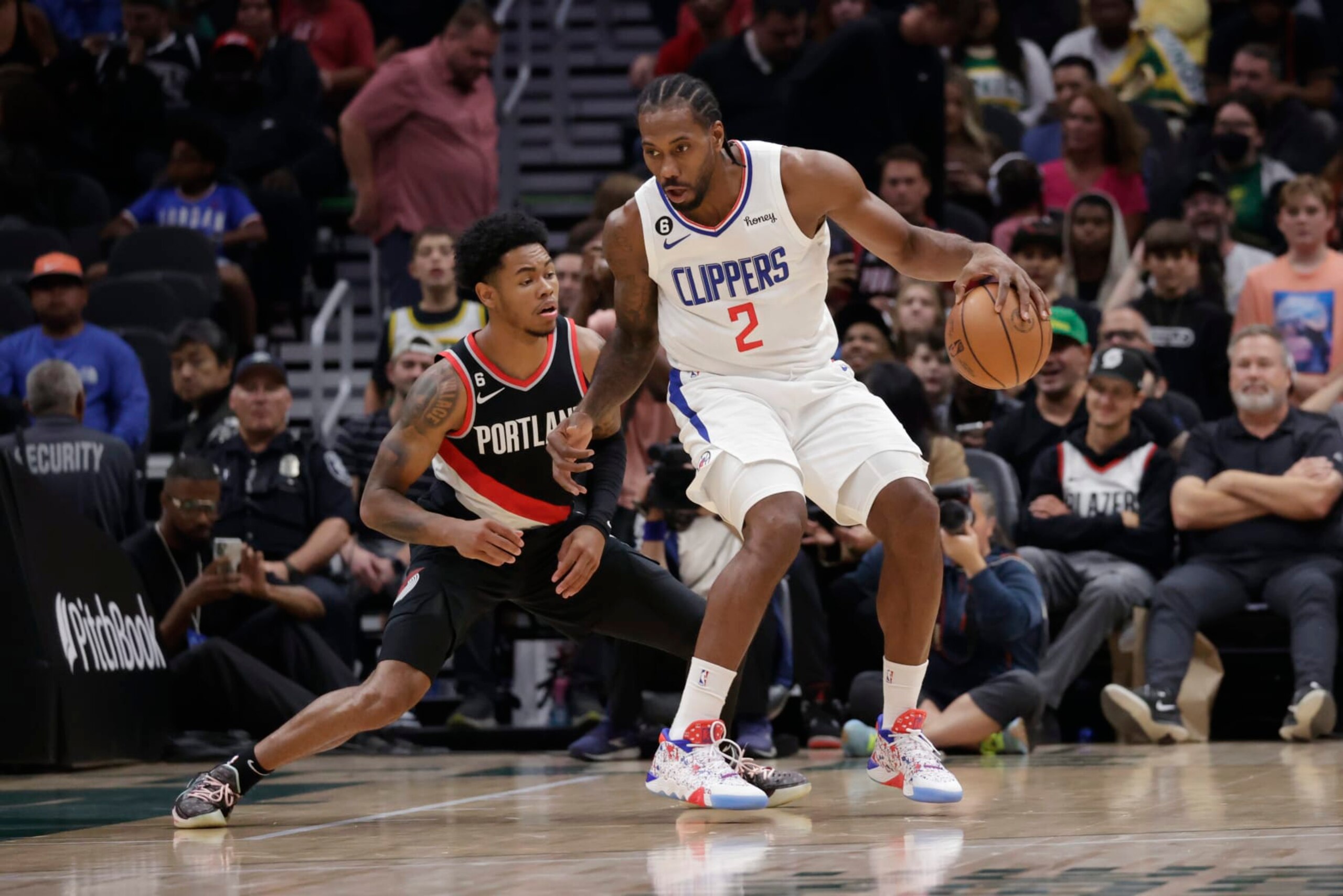 Los Angeles Clippers' Kawhi Leonard dribbles the ball with Portland Trailblazers' Anfernee Simons defending during the first half of a preseason NBA basketball game, Monday, Oct. 3, 2022, in Seattle. (AP Photo/ John Froschauer)