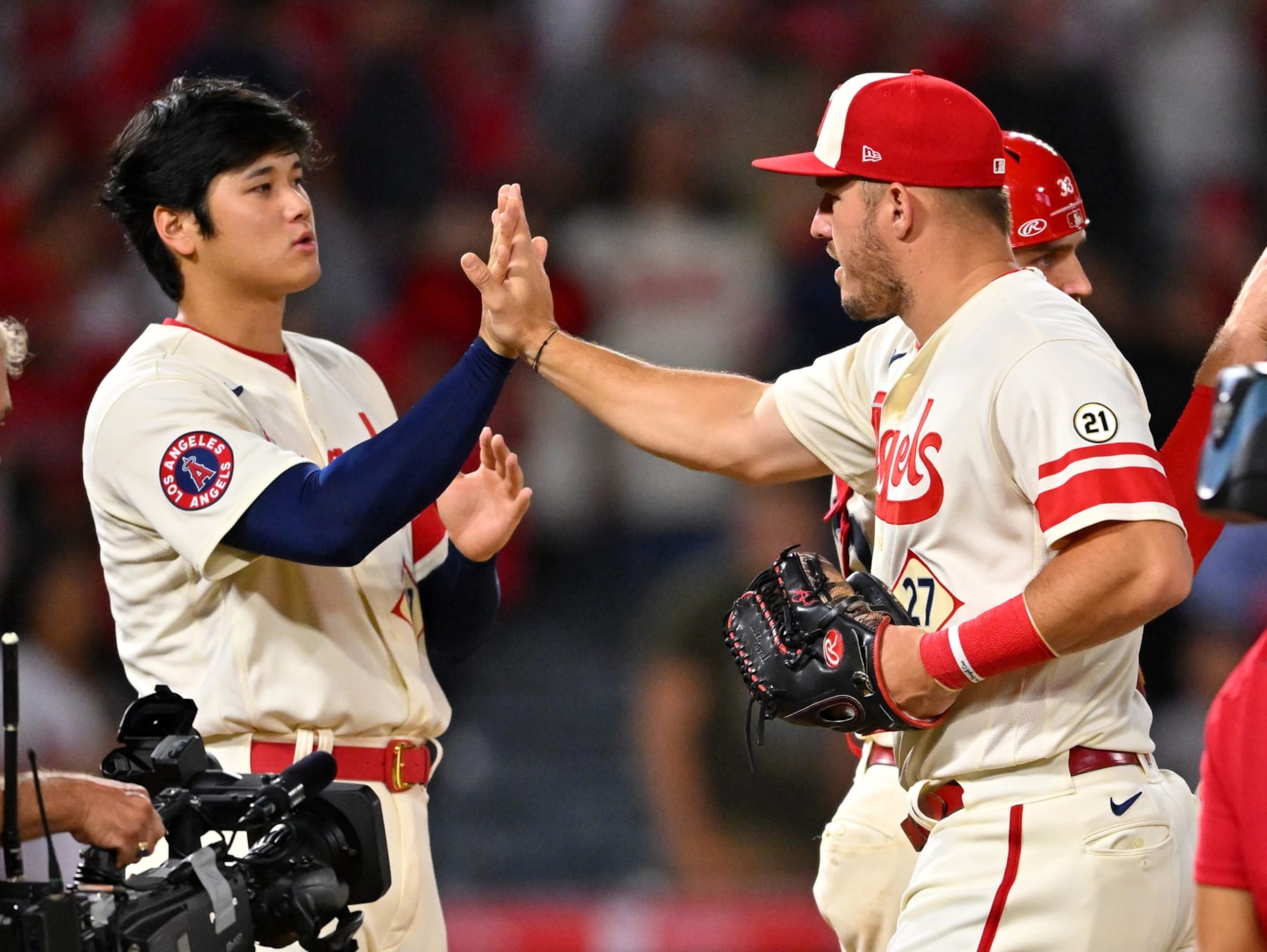 ANAHEIM, CA - SEPTEMBER 16: Shohei Ohtani #17 and Mike Trout #27 of the Los Angeles Angels high five as they leave the field after the final out of the ninth inning defeating the Seattle Mariners at Angel Stadium of Anaheim on September 16, 2022 in Anaheim, California. (Photo by Jayne Kamin-Oncea/Getty Images)