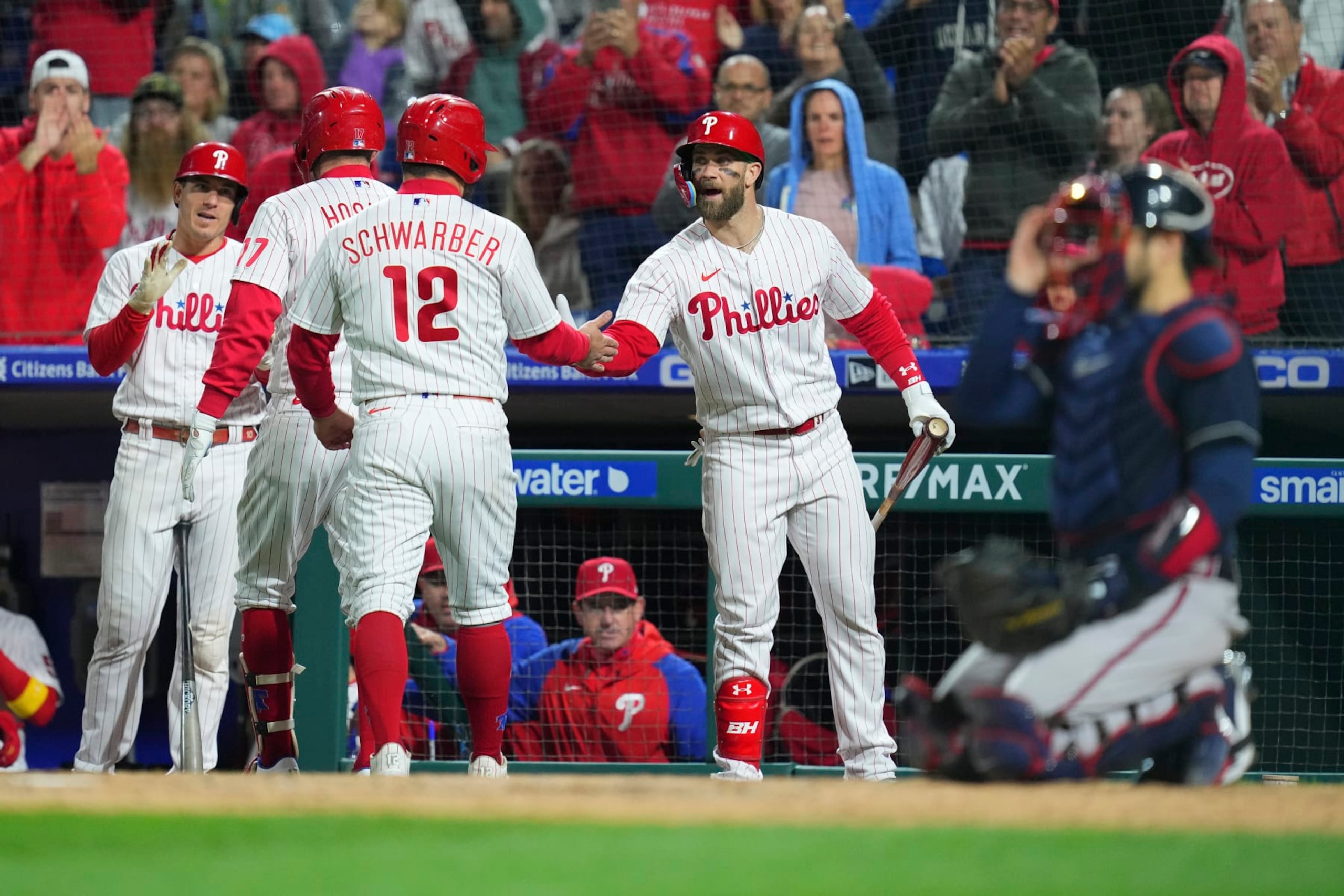 PHILADELPHIA, PA - SEPTEMBER 23: J.T. Realmuto #10, Rhys Hoskins #17, Kyle Schwarber #12, and Bryce Harper #3 of the Philadelphia Phillies react after a two run home run by Hoskins in the bottom fourth inning against the Atlanta Braves at Citizens Bank Park on September 23, 2022 in Philadelphia, Pennsylvania. The Phillies defeated the Braves 9-1. (Photo by Mitchell Leff/Getty Images)