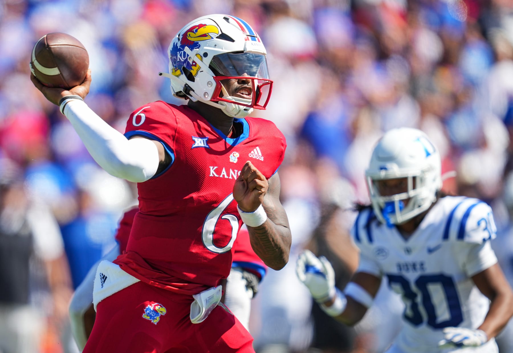 LAWRENCE, KS - SEPTEMBER 24: Jalon Daniels #6 of the Kansas Jayhawks throws a pass as Brandon Johnson #30 of the Duke Blue Devils defends during the second half at David Booth Kansas Memorial Stadium on September 24, 2022 in Lawrence, Kansas. Kansas defeated Duke 35-27. (Photo by Jay Biggerstaff/Getty Images)