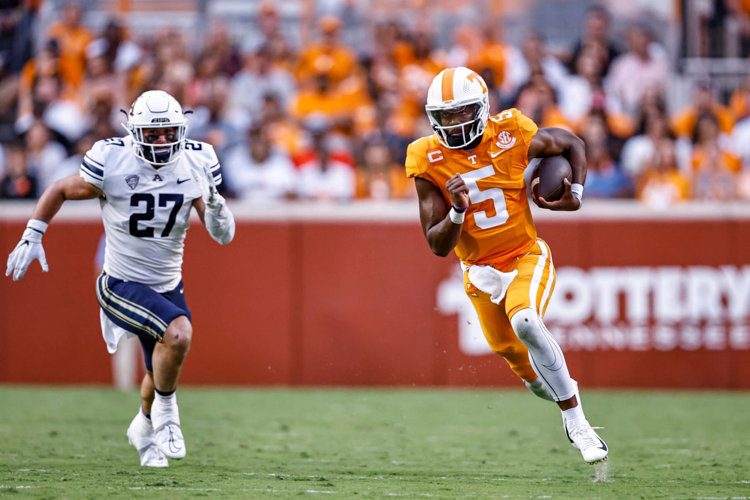 Tennessee quarterback Hendon Hooker (5) runs for yardage as he's chased by Akron linebacker Bubba Arslanian (27) during the first half of an NCAA college football game, Saturday, Sept. 17, 2022, in Knoxville, Tenn. (AP Photo/Wade Payne)