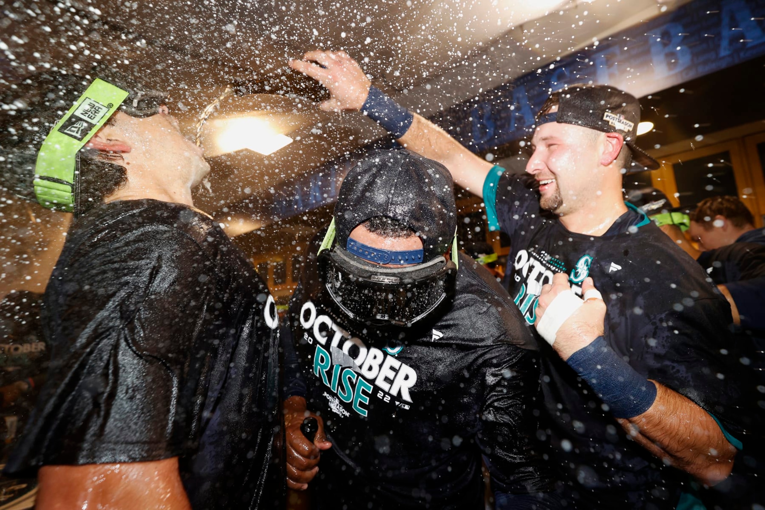 SEATTLE, WASHINGTON - SEPTEMBER 30: Marco Gonzales #7 and Cal Raleigh #29 of the Seattle Mariners celebrate with teammates in the clubhouse after clinching a postseason birth after beating the Oakland Athletics 2-1 at T-Mobile Park on September 30, 2022 in Seattle, Washington. The Seattle Mariners have clinched a postseason appearance for the first time  in 21 years, the longest playoff drought in North American professional sports. (Photo by Steph Chambers/Getty Images)