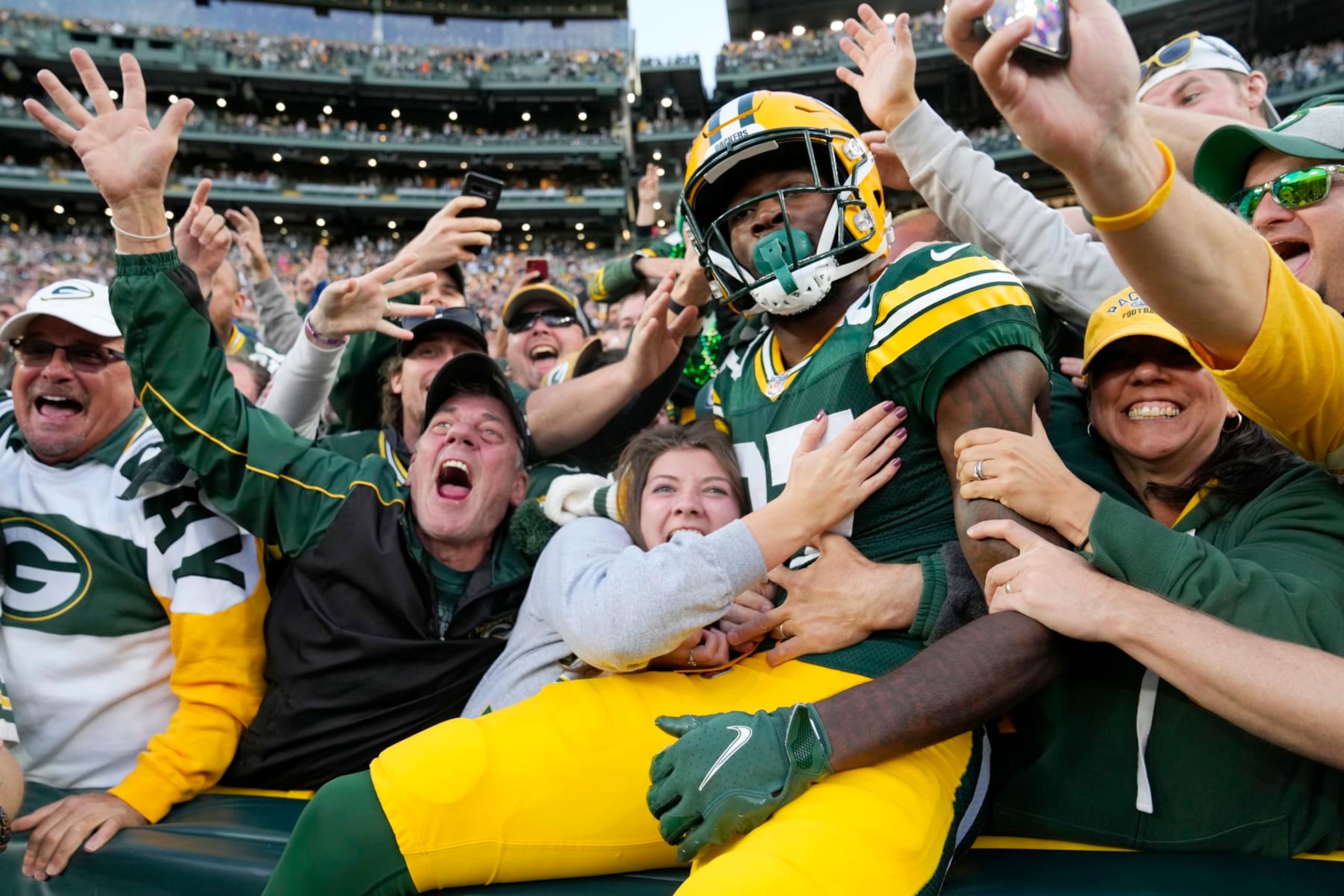 GREEN BAY, WISCONSIN - OCTOBER 02: Fans celebrate with Romeo Doubs #87 of the Green Bay Packers after his touchdown 
during the fourth quarter against the New England Patriots at Lambeau Field on October 02, 2022 in Green Bay, Wisconsin. (Photo by Patrick McDermott/Getty Images)