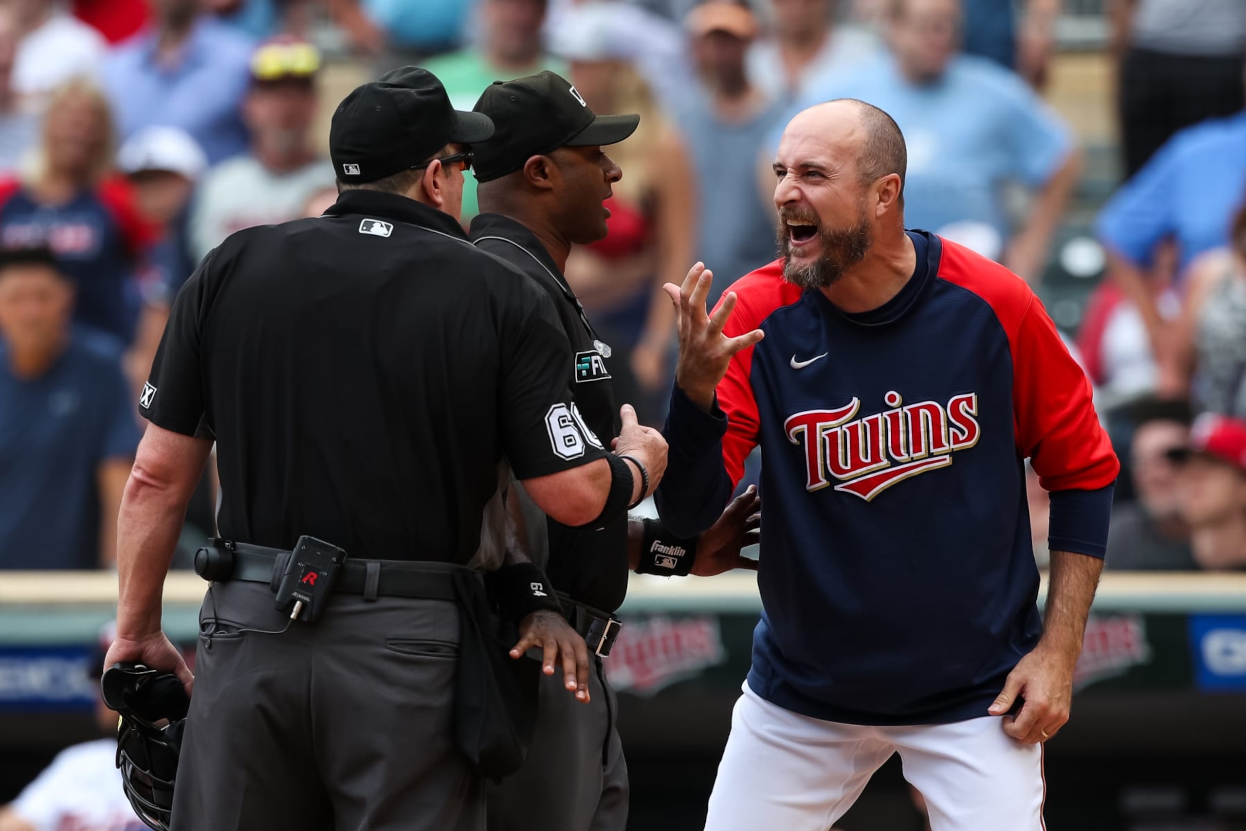 MINNEAPOLIS, MN - AUGUST 07: Rocco Baldelli #5 of the Minnesota Twins argues with umpires Alan Porter #64 and Marty Foster #60 after a coach's challenge determined Whit Merrifield #1 of the Toronto Blue Jays scored a run at home plate against Gary Sanchez #24 of the Minnesota Twins due to Sanchez blocking the plate in the tenth inning of the game at Target Field on August 7, 2022 in Minneapolis, Minnesota. The Blue Jays defeated the Twins 3-2 in ten innings. (Photo by David Berding/Getty Images)
