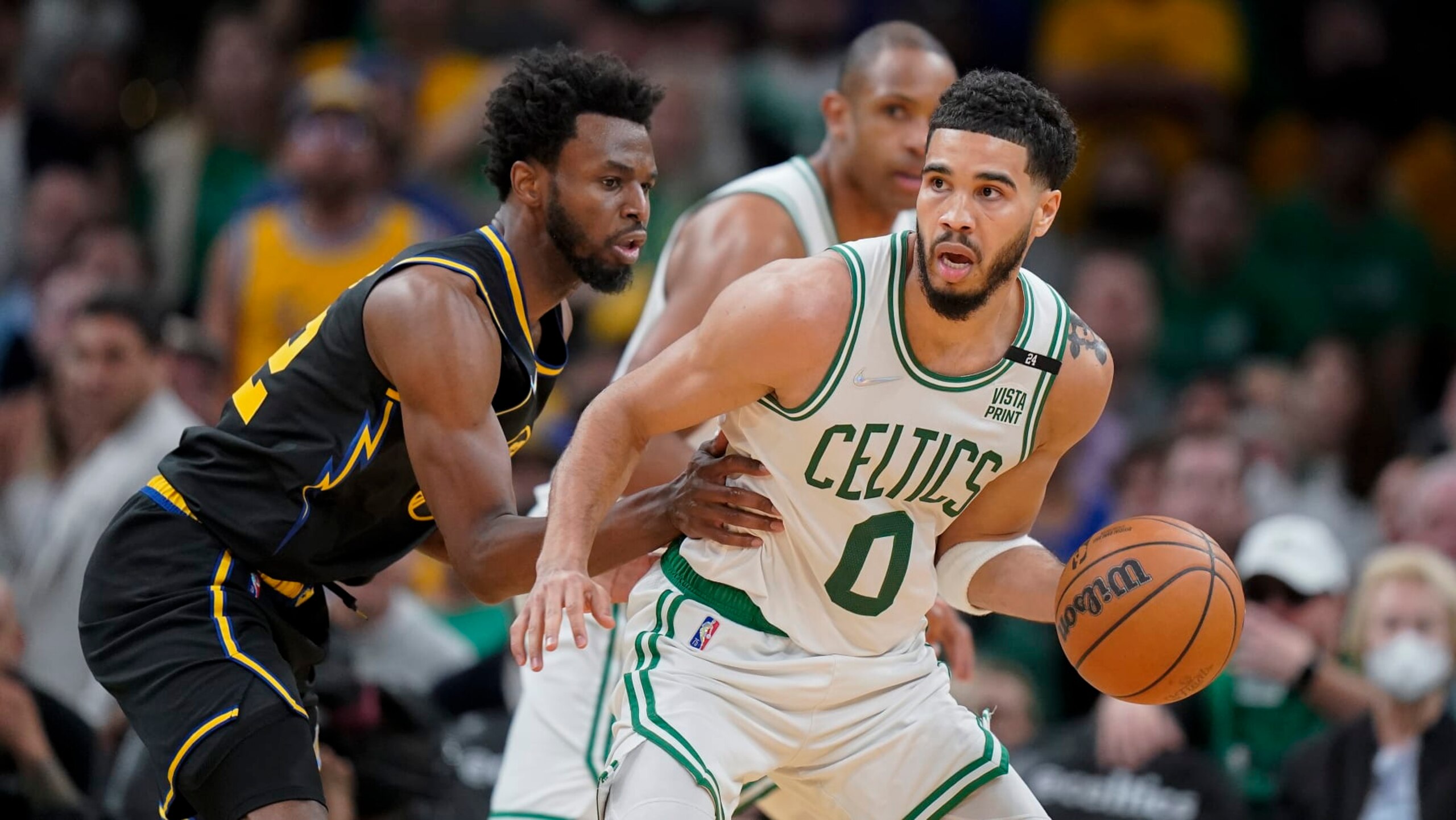 Boston Celtics forward Jayson Tatum (0) looks to drive against Golden State Warriors forward Andrew Wiggins (22) during Game 3 of basketball's NBA Finals, Wednesday, June 8, 2022, in Boston. (AP Photo/Steven Senne)
