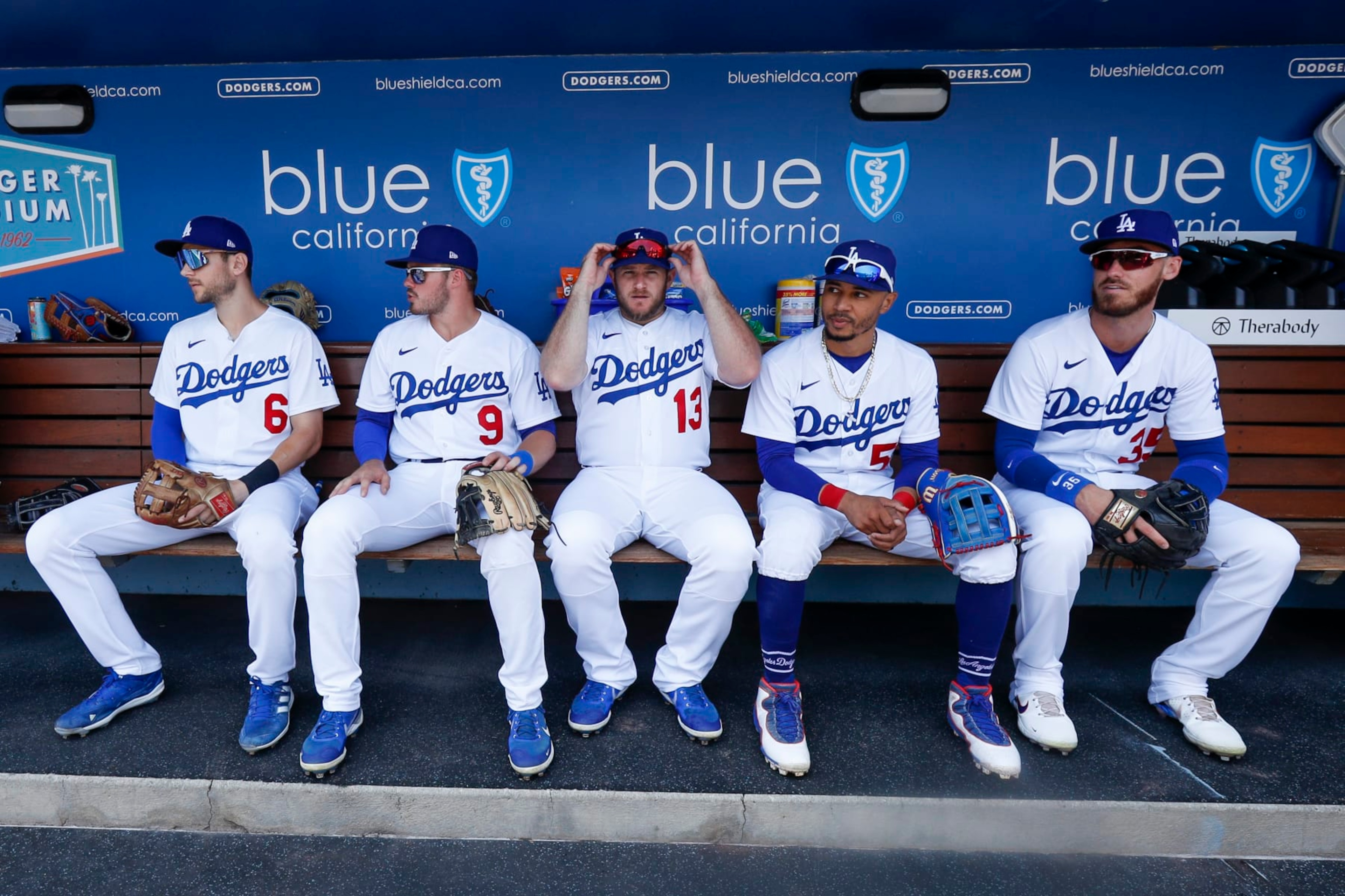 LOS ANGELES, CA - JULY 24: Los Angeles Dodgers first baseman Freddie Freeman (5), shortstop Trea Turner (6), second baseman Gavin Lux (9),  third baseman Max Muncy (13), right fielder Mookie Betts (50), and center fielder Cody Bellinger (35) sit in the dugout prior to a regular season game between the San Francisco Giants and Los Angeles Dodgers on July 24, 2022, at Dodger Stadium in Los Angeles, CA. (Photo by Brandon Sloter/Icon Sportswire via Getty Images)