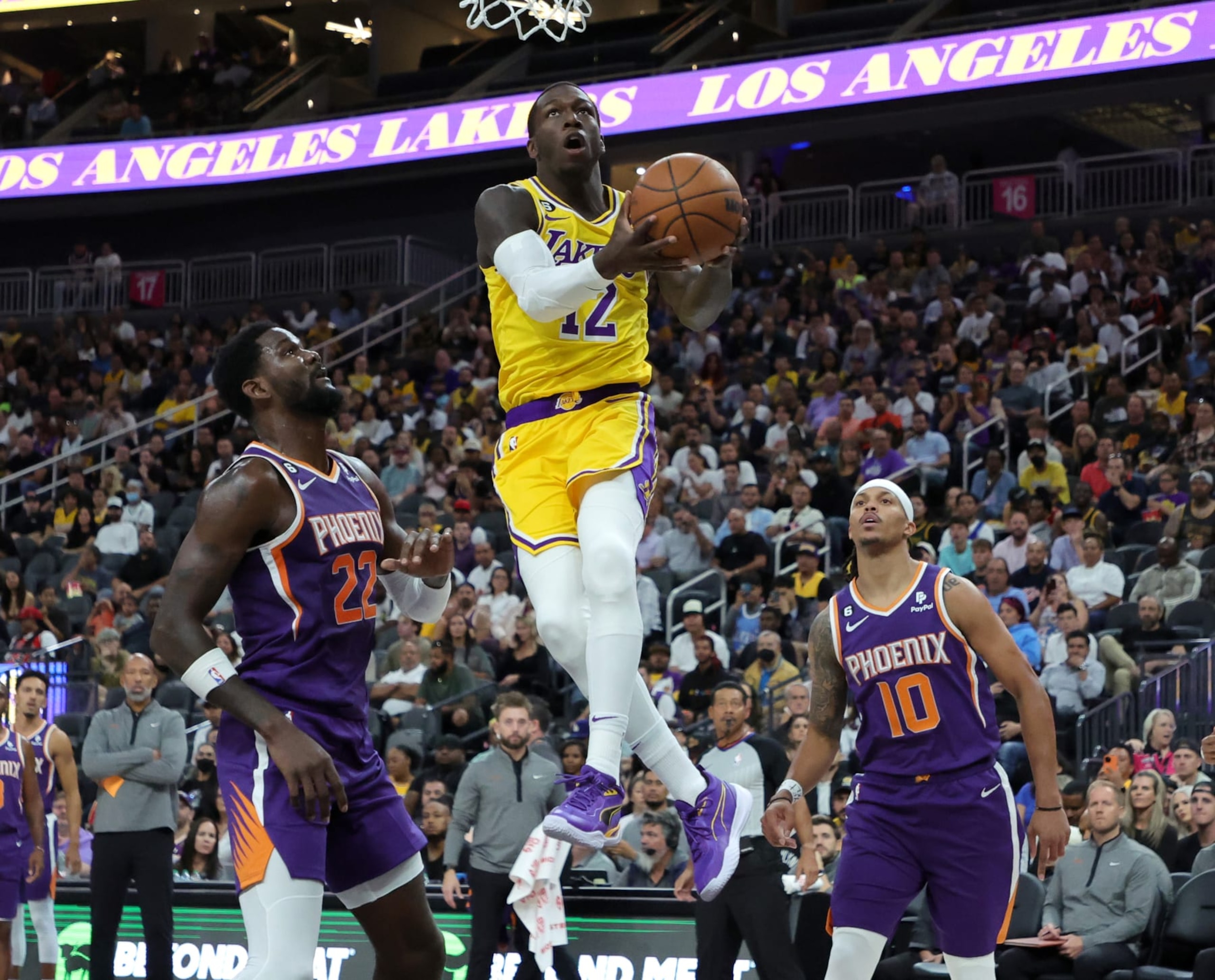 LAS VEGAS, NEVADA - OCTOBER 05: Kendrick Nunn #12 of the Los Angeles Lakers drives to the basket against Deandre Ayton #22 of the Phoenix Suns as Damion Lee #10 of the Suns defends in the first quarter of their preseason game at T-Mobile Arena on October 05, 2022 in Las Vegas, Nevada. NOTE TO USER: User expressly acknowledges and agrees that, by downloading and or using this photograph, User is consenting to the terms and conditions of the Getty Images License Agreement. (Photo by Ethan Miller/Getty Images)