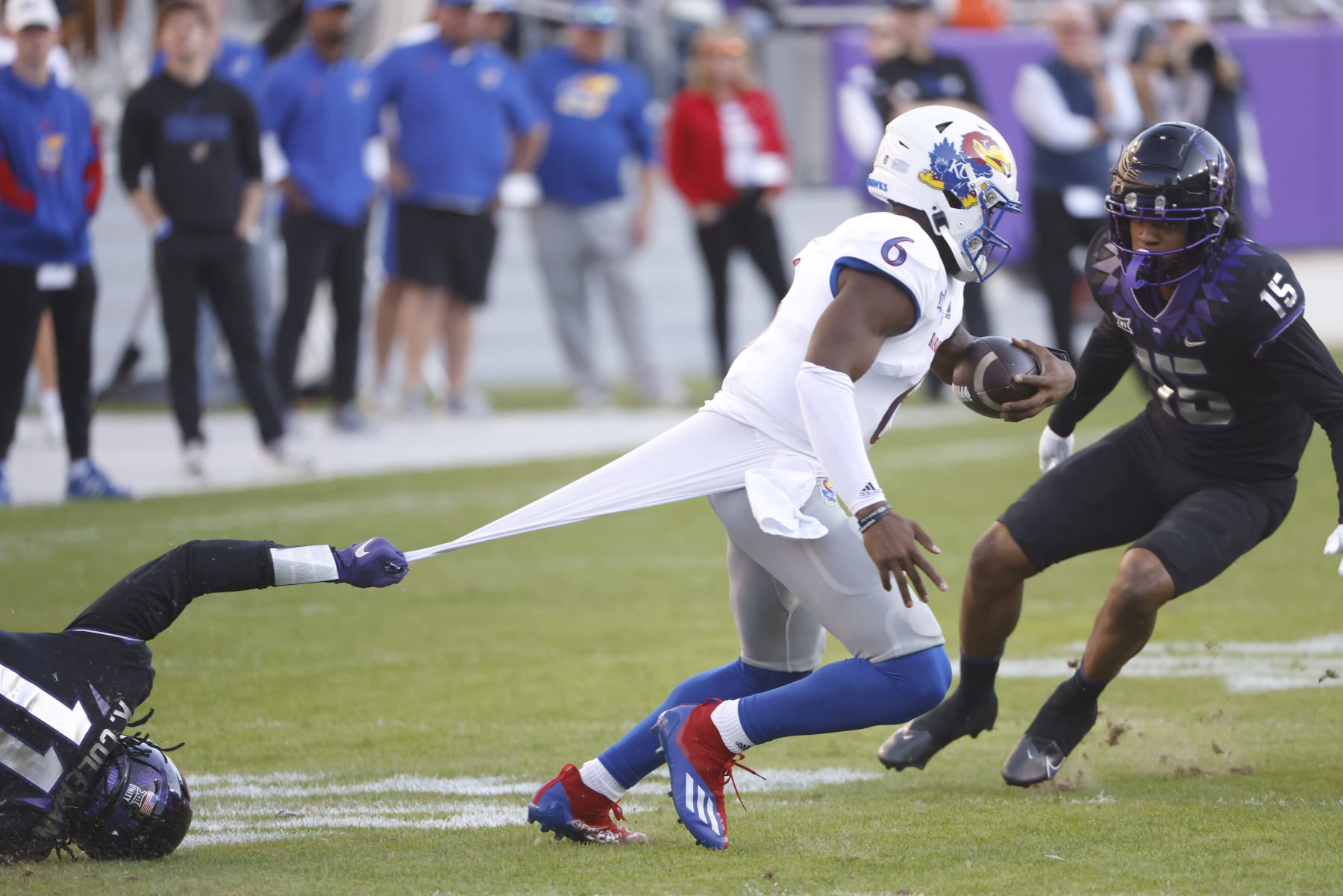 Kansas quarterback Jalon Daniels (6) is caught by TCU defensive end Khari Coleman (11) as safety Josh Foster (15) moves in during the first half of an NCAA college football game Saturday, Nov. 20, 2021, in Fort Worth, Texas. (AP Photo/Ron Jenkins)