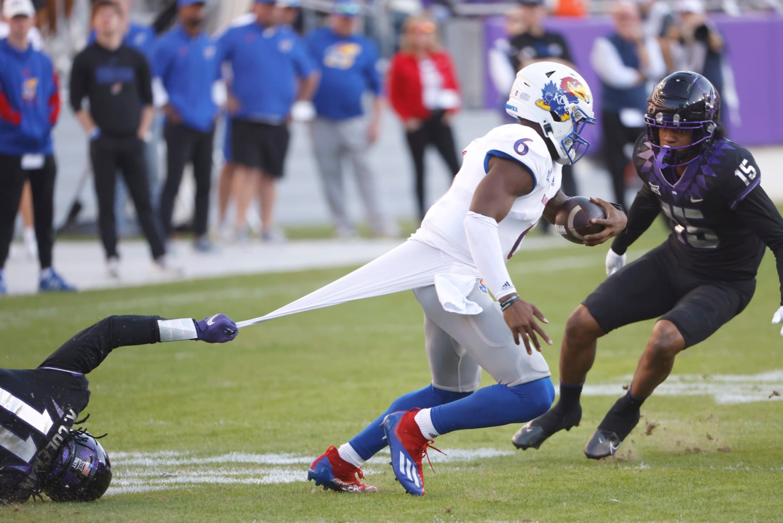 Kansas quarterback Jalon Daniels (6) is caught by TCU defensive end Khari Coleman (11) as safety Josh Foster (15) moves in during the first half of an NCAA college football game Saturday, Nov. 20, 2021, in Fort Worth, Texas. (AP Photo/Ron Jenkins)