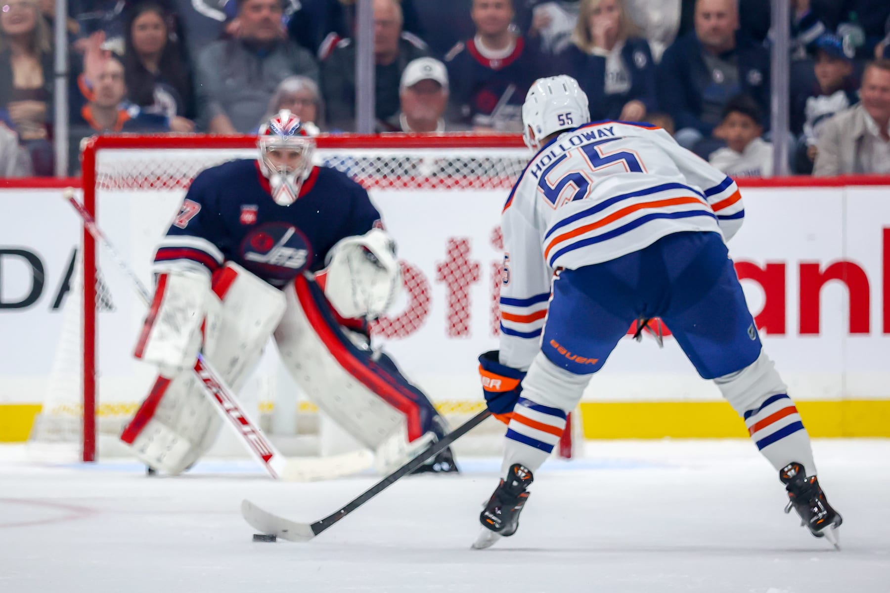 WINNIPEG, CANADA - OCTOBER 1: Dylan Holloway #55 of the Edmonton Oilers carries the puck down the ice during a second period breakaway on goaltender Connor Hellebuyck #37 of the Winnipeg Jets during pre-season action at the Canada Life Centre on October 1, 2022 in Winnipeg, Manitoba, Canada. (Photo by Jonathan Kozub/NHLI via Getty Images)