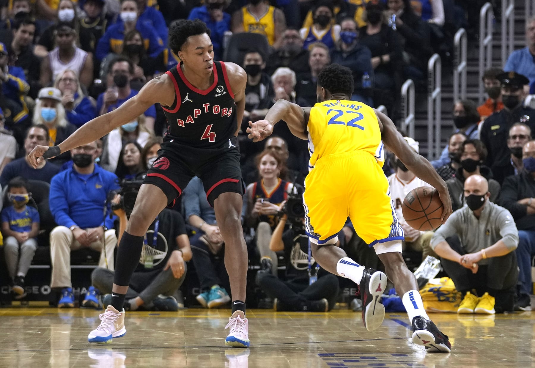 SAN FRANCISCO, CALIFORNIA - NOVEMBER 21: Andrew Wiggins #22 of the Golden State Warriors drives to the basket on Scottie Barnes #4 of the Toronto Raptors during the first half of an NBA basketball game at Chase Center on November 21, 2021 in San Francisco, California. NOTE TO USER: User expressly acknowledges and agrees that, by downloading and or using this photograph, User is consenting to the terms and conditions of the Getty Images License Agreement. (Photo by Thearon W. Henderson/Getty Images)