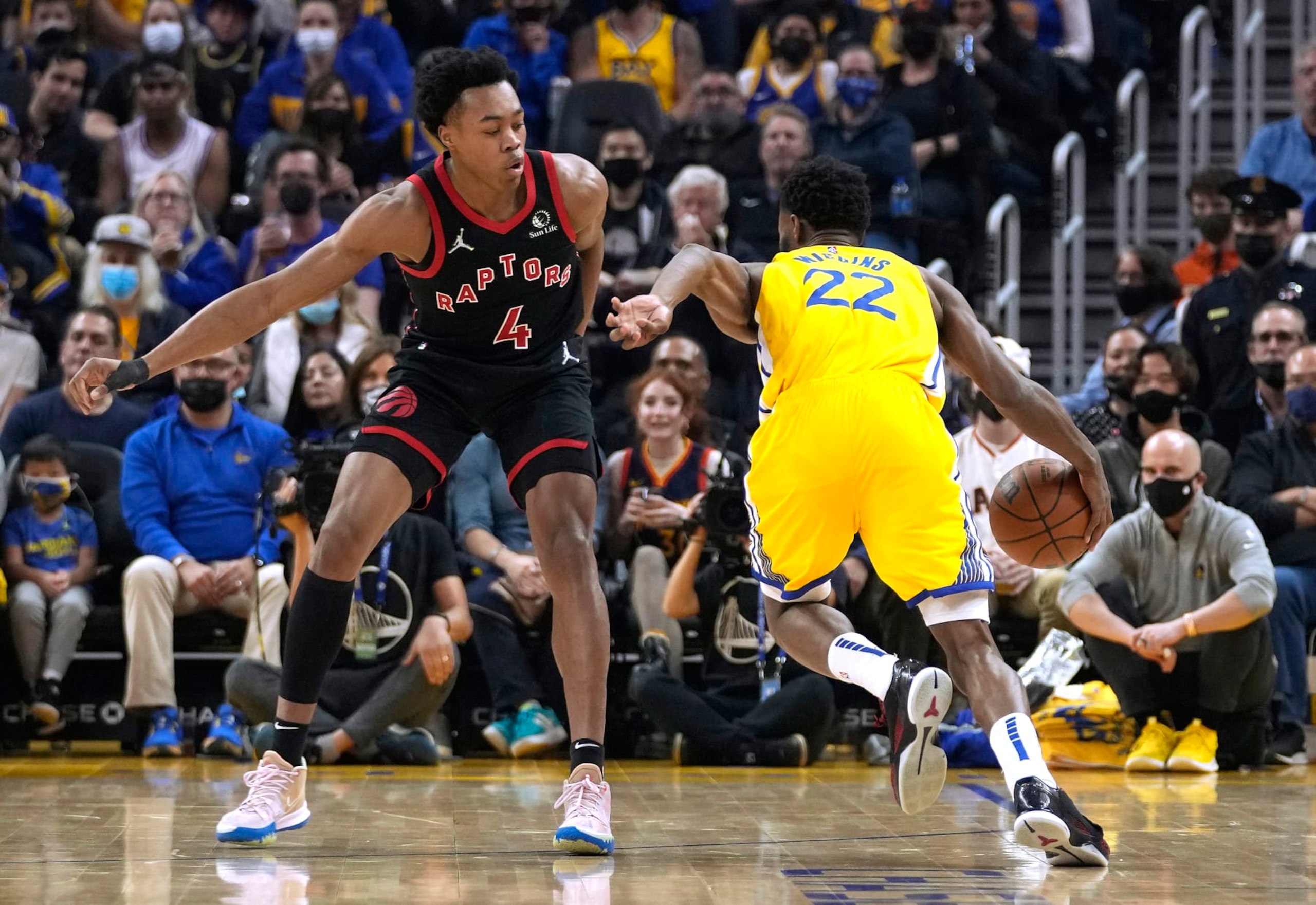 SAN FRANCISCO, CALIFORNIA - NOVEMBER 21: Andrew Wiggins #22 of the Golden State Warriors drives to the basket on Scottie Barnes #4 of the Toronto Raptors during the first half of an NBA basketball game at Chase Center on November 21, 2021 in San Francisco, California. NOTE TO USER: User expressly acknowledges and agrees that, by downloading and or using this photograph, User is consenting to the terms and conditions of the Getty Images License Agreement. (Photo by Thearon W. Henderson/Getty Images)