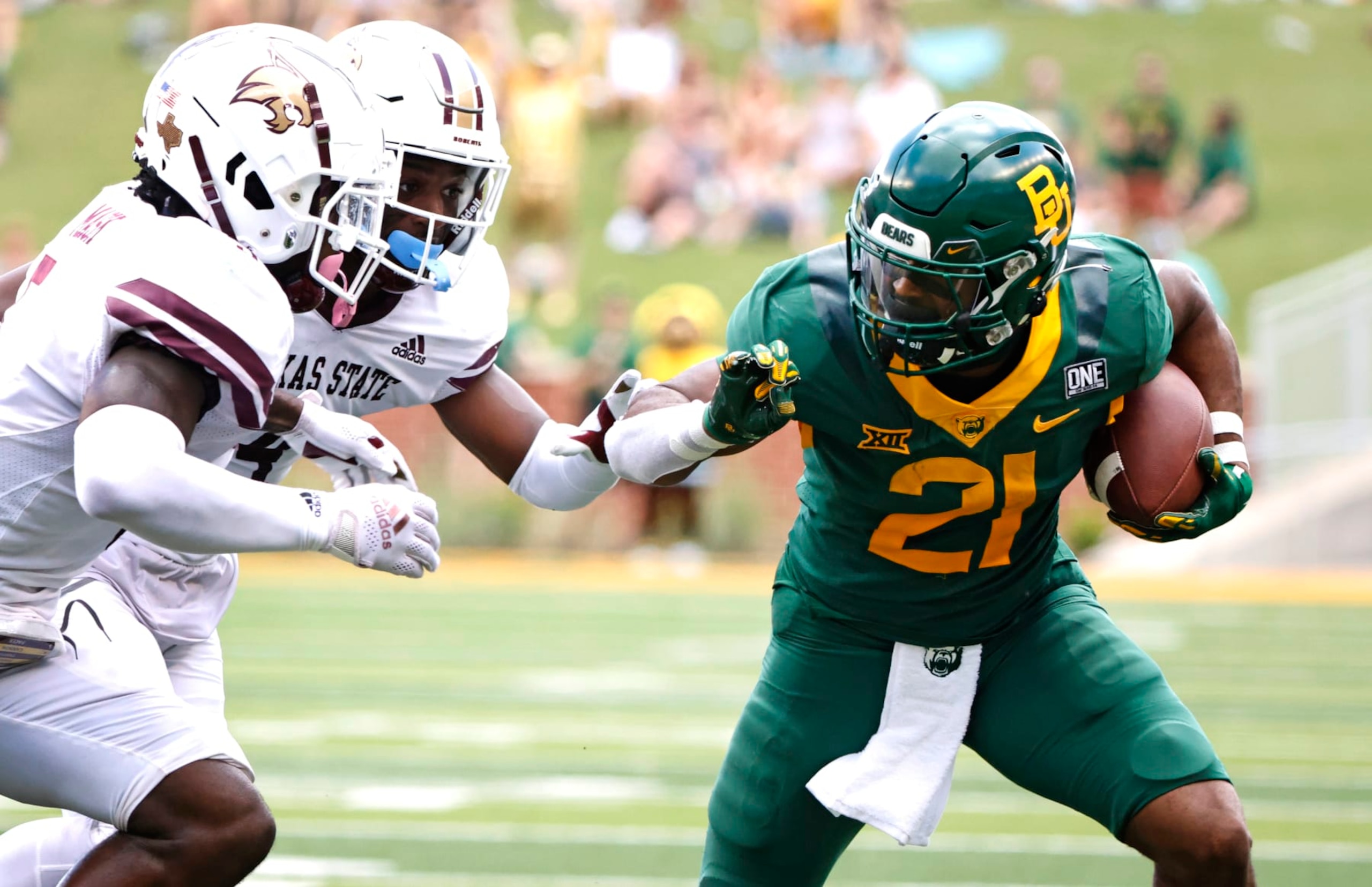 WACO, TX - SEPTEMBER 17: Josh Fleeks #21 of the Baylor Bears tries to elude DeJordan Mask #5 of the Texas State Bobcats and teammate Alonzo Edwards Jr. #4 in the second half at McLane Stadium on September 17, 2022 in Waco, Texas. Baylor won 42-7. (Photo by Ron Jenkins/Getty Images)