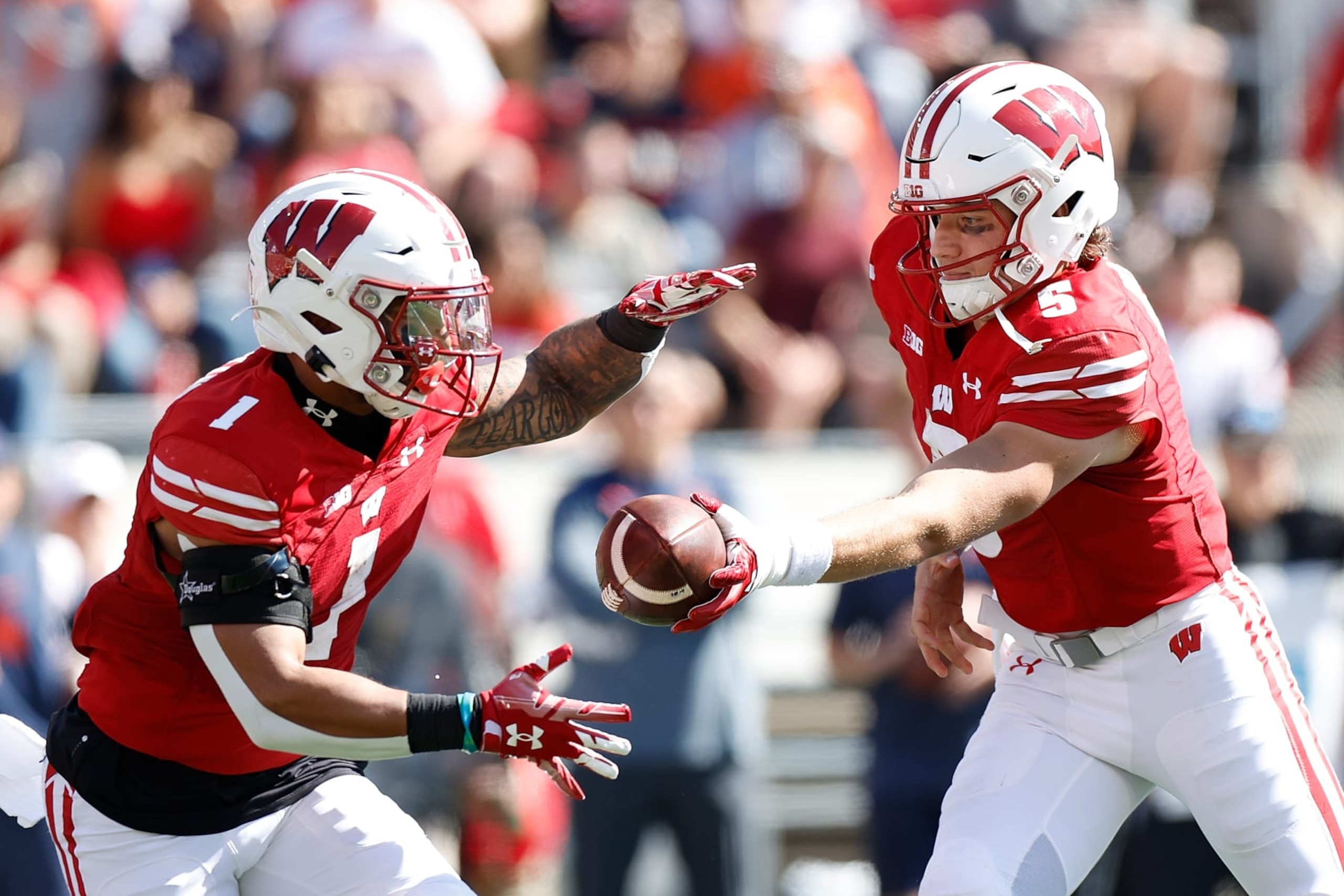 MADISON, WISCONSIN - OCTOBER 01: Graham Mertz #5 of the Wisconsin Badgers hands the ball off to Chez Mellusi #1 during the game against the Illinois Fighting Illini at Camp Randall Stadium on October 01, 2022 in Madison, Wisconsin. (Photo by John Fisher/Getty Images)