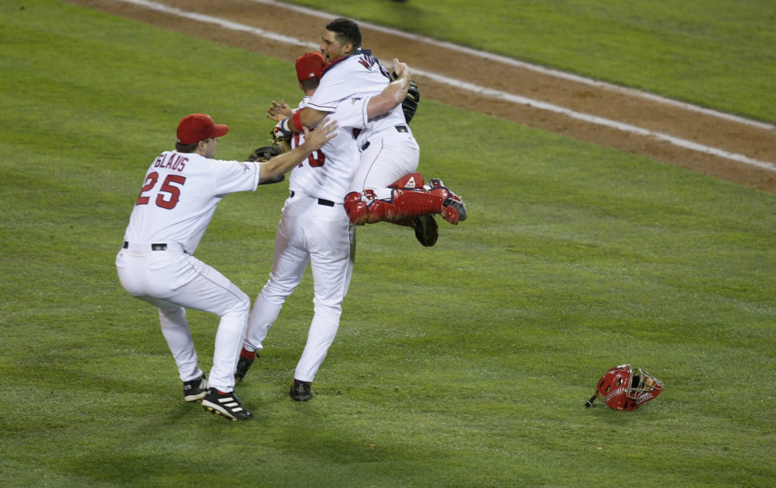 ANAHEIM, CA - OCTOBER 27:  Catcher Bengie Molina #1 of the Anaheim Angels jumps into the arms of closing pitcher Troy Percival #40 as they celebrate the win with teammate Troy Glaus #25 (left) at the end of World Series game seven against the San Francisco Giants at Edison Field in Anaheim, California on October 27, 2002.  The Angels won the title against the Giants on a 4-1 score, for the franchise's first championship in 42 years.  (Photo by Donald Miralle/Getty Images) 