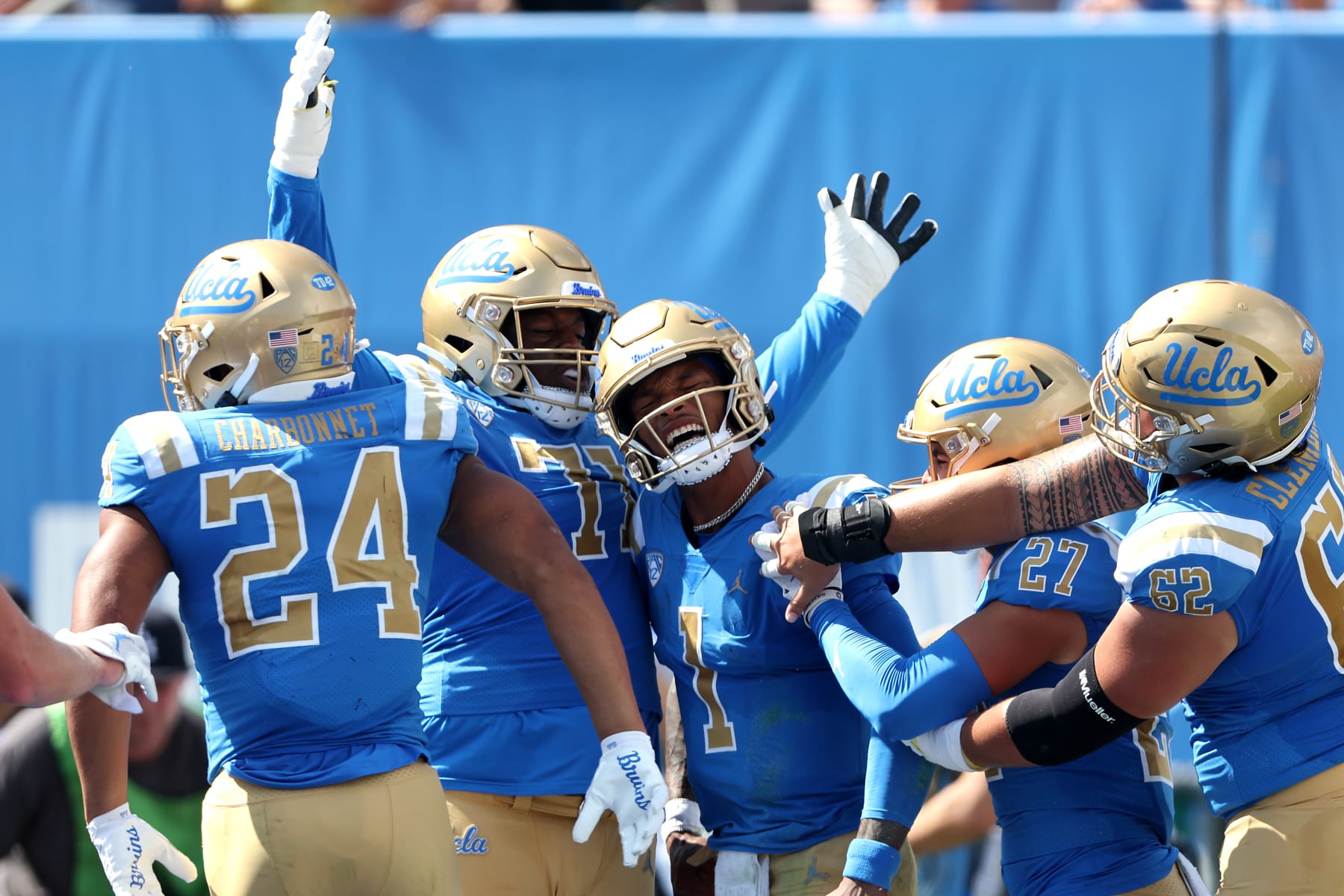 PASADENA, CALIFORNIA - OCTOBER 08: Ashton Authement #27, Zach Charbonnet #24 and Raiqwon O'Neal #71 congratulates Dorian Thompson-Robinson #1 of the UCLA Bruins after he scored a rushing touchdown during the first half of a game against the Utah Utes at Rose Bowl on October 08, 2022 in Pasadena, California. (Photo by Sean M. Haffey/Getty Images)