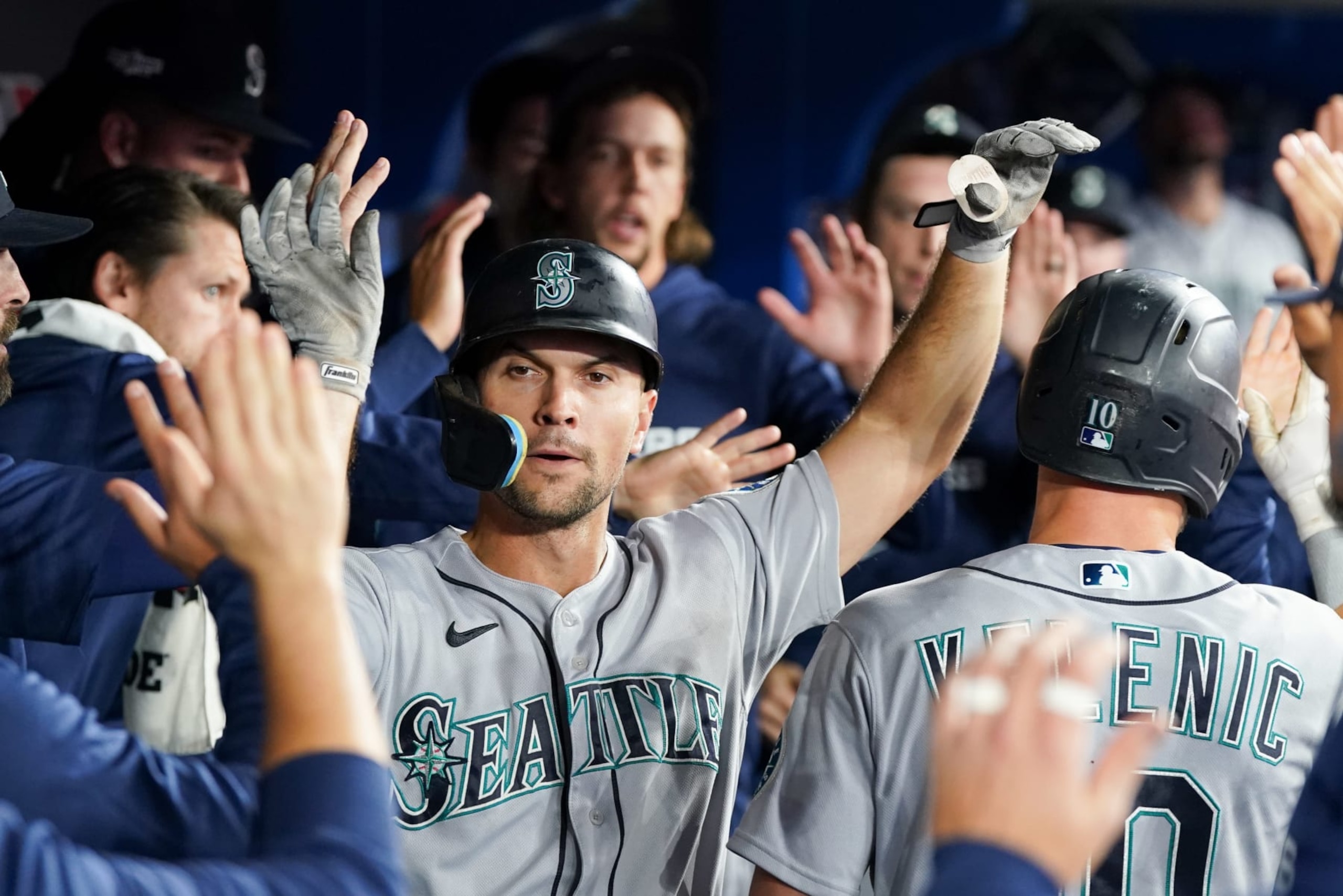 TORONTO,  - OCTOBER 08:   Adam Frazier #26 of the Seattle Mariners high-fives teammates in the dugout after scoring in the fifth inning during the Wild Card Series game between the Seattle Mariners and the Toronto Blue Jays at Rogers Centre on Saturday, October 8, 2022 in Toronto, Canada. (Photo by Thomas Skrlj/MLB Photos via Getty Images)
