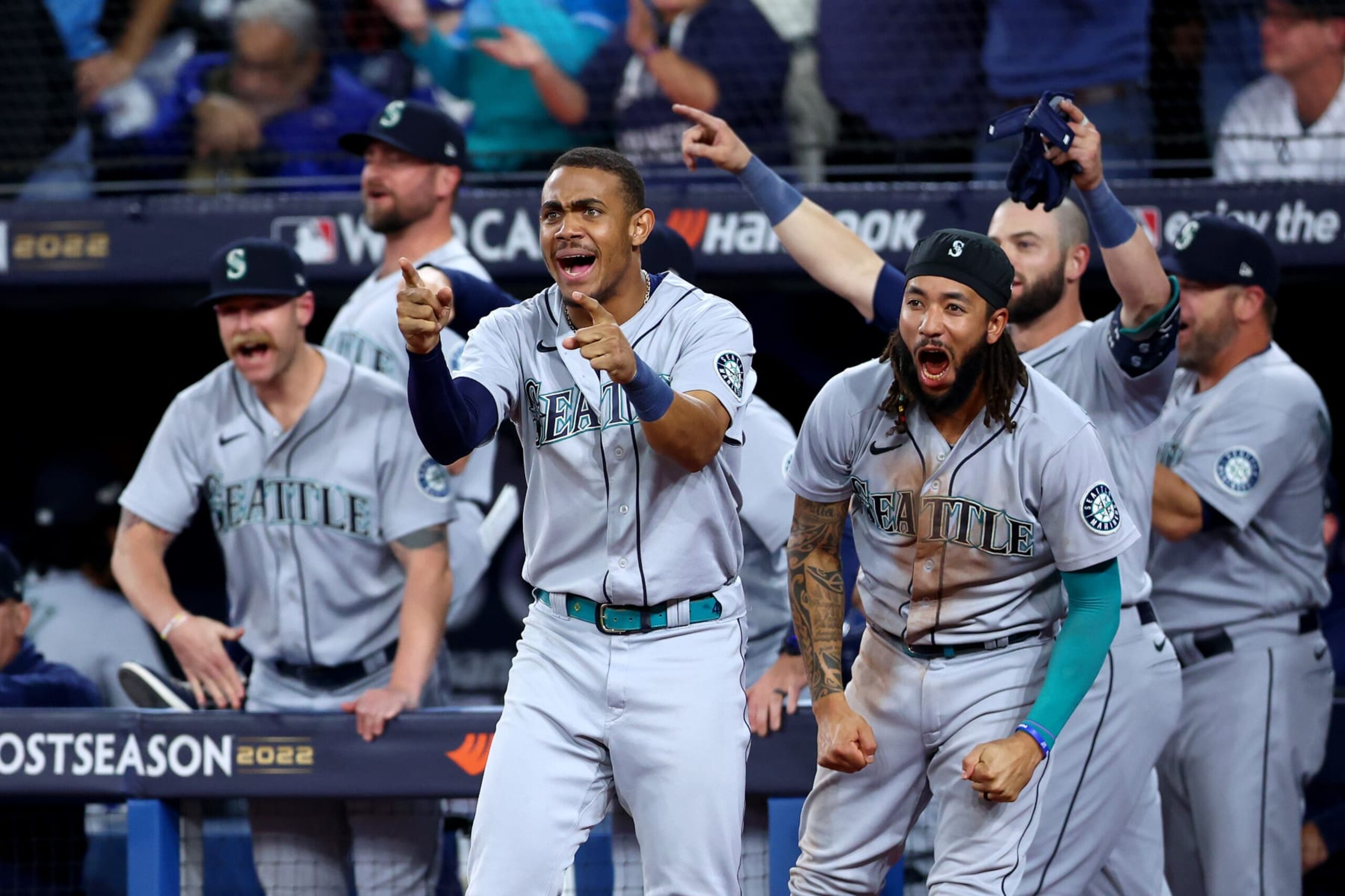 TORONTO, ONTARIO - OCTOBER 08: Julio Rodriguez #44 and J.P. Crawford #3 of the Seattle Mariners celebrate Adam Frazier #26 RBI double to take the lead against the Toronto Blue Jays during the ninth inning in game two of the American League Wild Card Series at Rogers Centre on October 08, 2022 in Toronto, Ontario. (Photo by Vaughn Ridley/Getty Images)