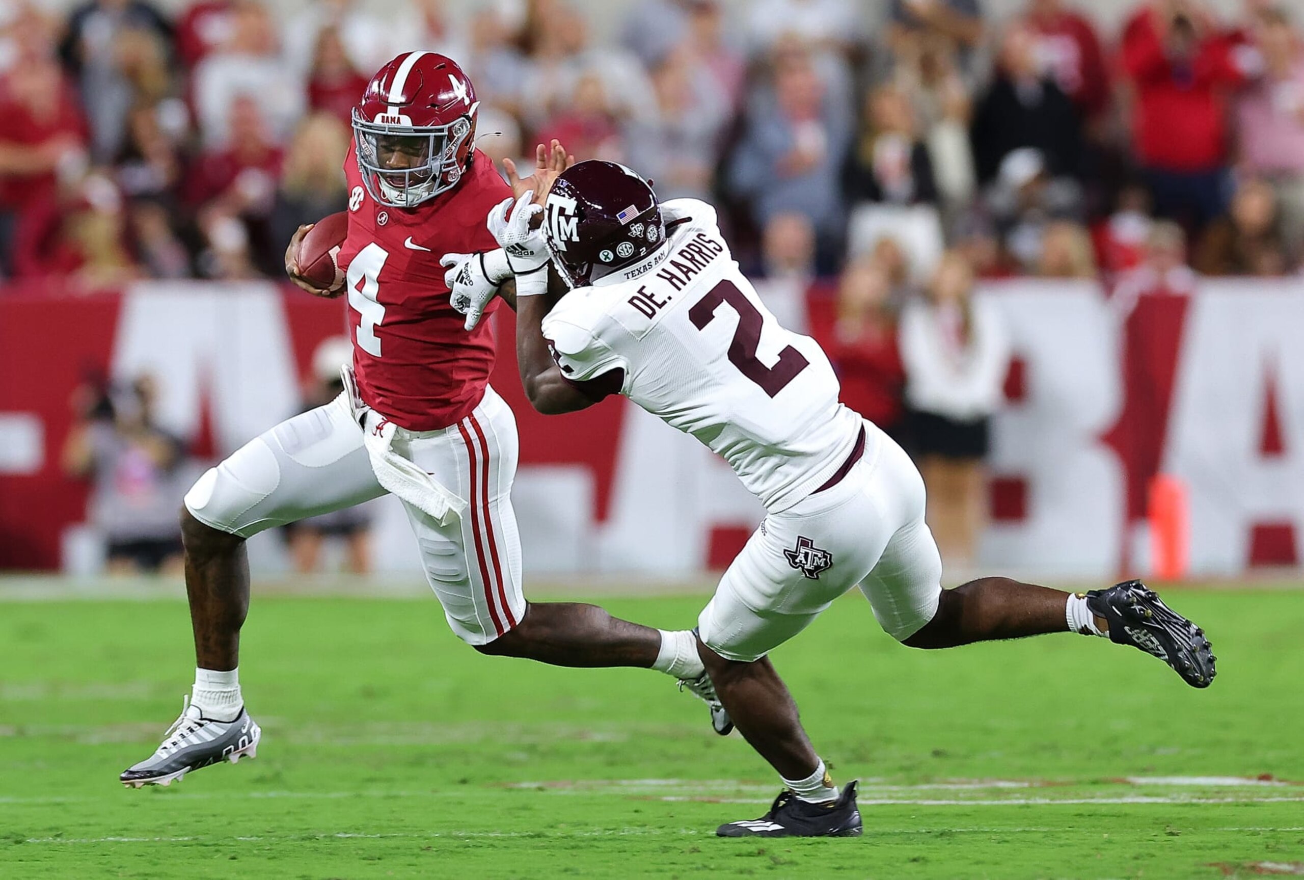 TUSCALOOSA, ALABAMA - OCTOBER 08:  Jalen Milroe #4 of the Alabama Crimson Tide rushes away from Denver Harris #2 of the Texas A&M Aggies during the first half at Bryant-Denny Stadium on October 08, 2022 in Tuscaloosa, Alabama. (Photo by Kevin C. Cox/Getty Images)