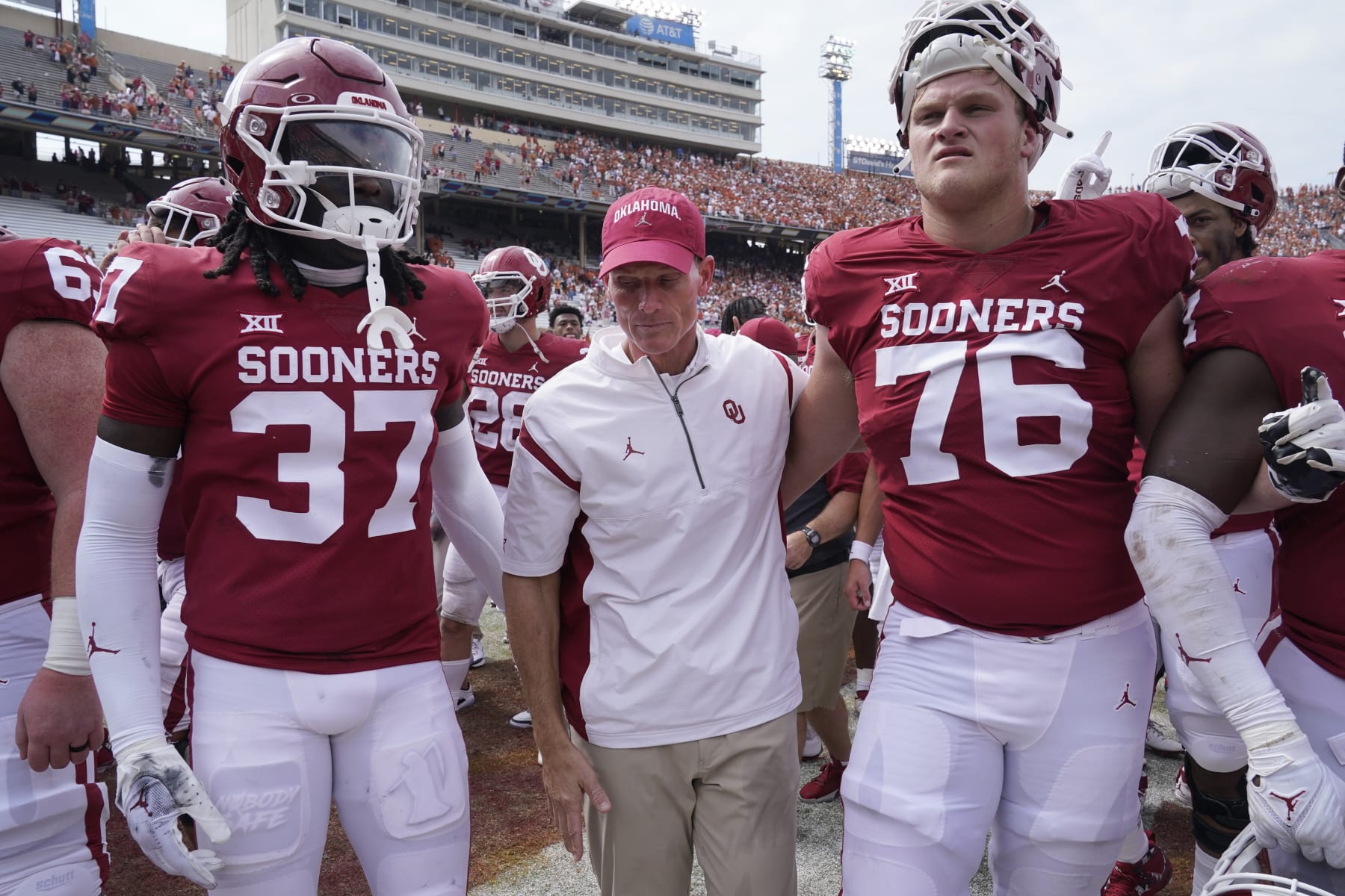 Oklahoma head coach Brent Venables, center, leaves the field with players Justin Harrington (37) and Jacob Sexton (76) after losing 49-0 to Texas in an NCAA college football game at the Cotton Bowl in Dallas, Saturday, Oct. 8, 2022. (AP Photo/LM Otero)