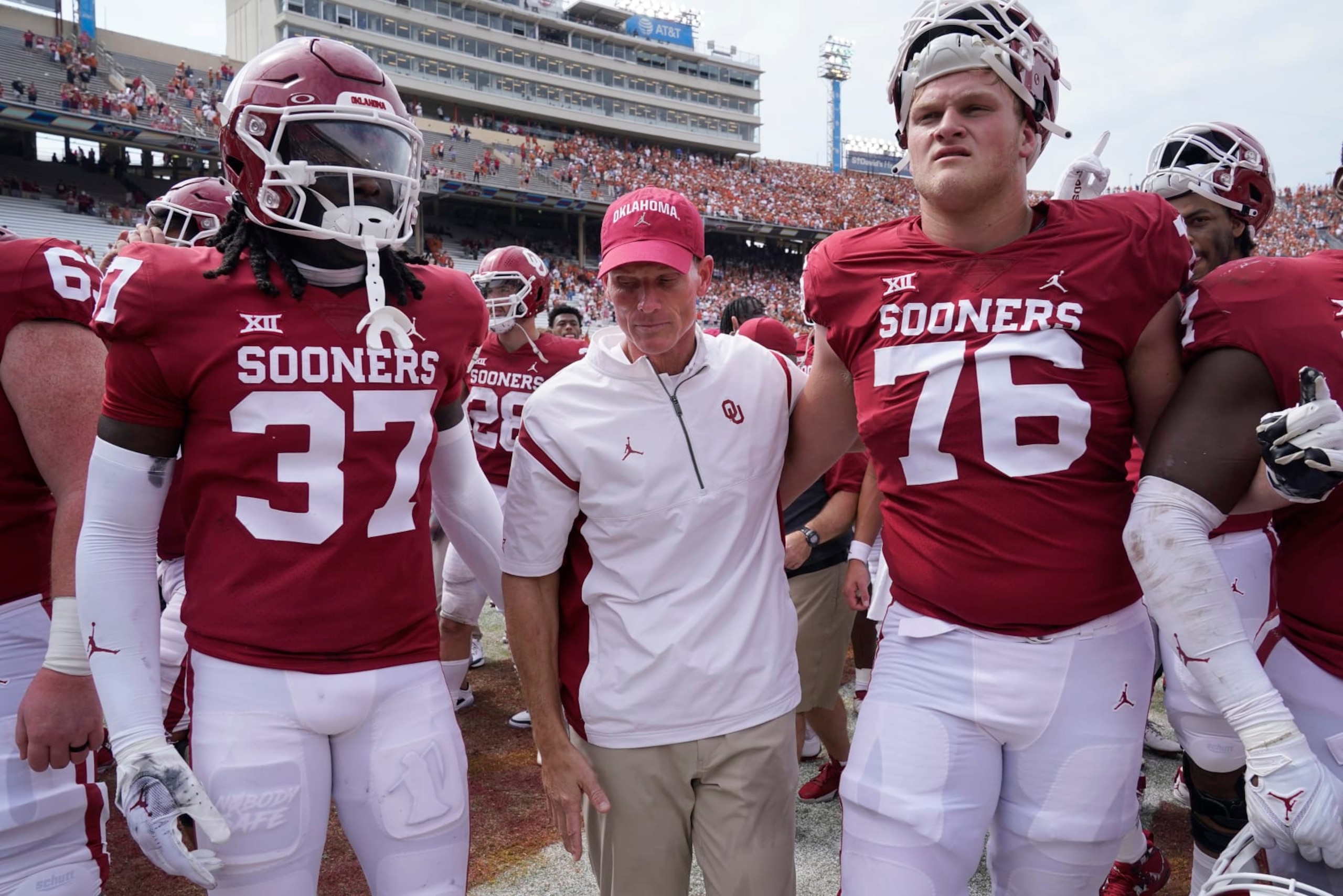 Oklahoma head coach Brent Venables, center, leaves the field with players Justin Harrington (37) and Jacob Sexton (76) after losing 49-0 to Texas in an NCAA college football game at the Cotton Bowl in Dallas, Saturday, Oct. 8, 2022. (AP Photo/LM Otero)
