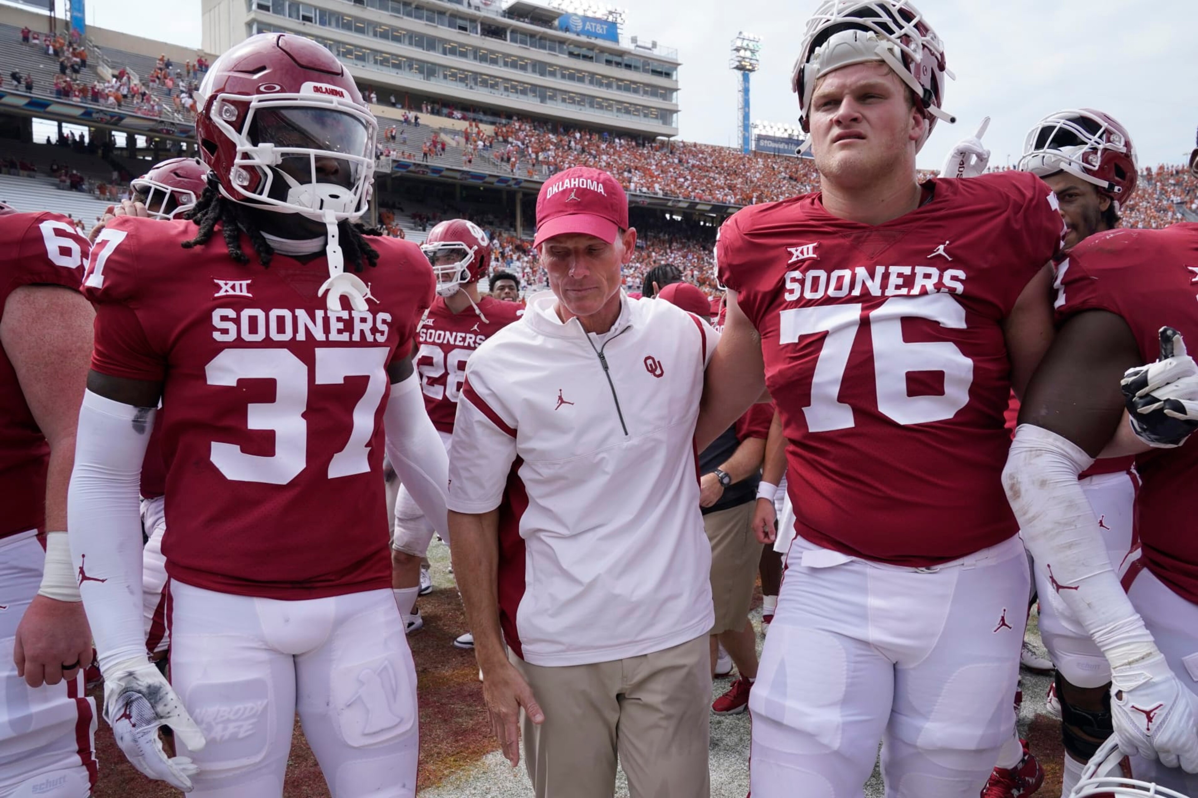 Oklahoma head coach Brent Venables, center, leaves the field with players Justin Harrington (37) and Jacob Sexton (76) after losing 49-0 to Texas in an NCAA college football game at the Cotton Bowl in Dallas, Saturday, Oct. 8, 2022. (AP Photo/LM Otero)