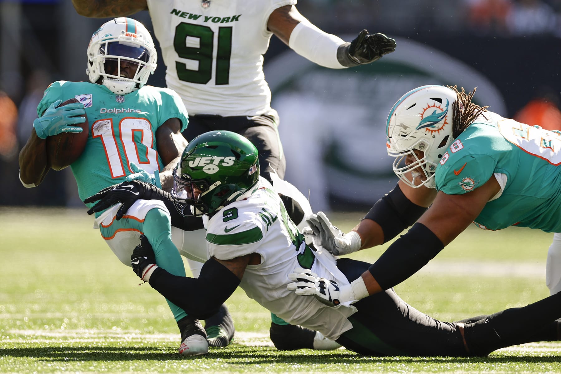 New York Jets linebacker Kwon Alexander (9) pulls down Miami Dolphins wide receiver Tyreek Hill (10) during the third quarter of an NFL football game, Sunday, Oct. 9, 2022, in East Rutherford, N.J. (AP Photo/Adam Hunger)
