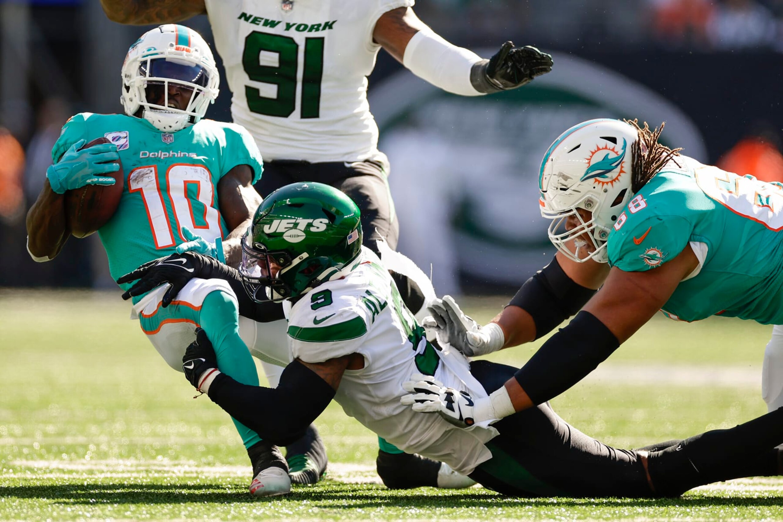 New York Jets linebacker Kwon Alexander (9) pulls down Miami Dolphins wide receiver Tyreek Hill (10) during the third quarter of an NFL football game, Sunday, Oct. 9, 2022, in East Rutherford, N.J. (AP Photo/Adam Hunger)