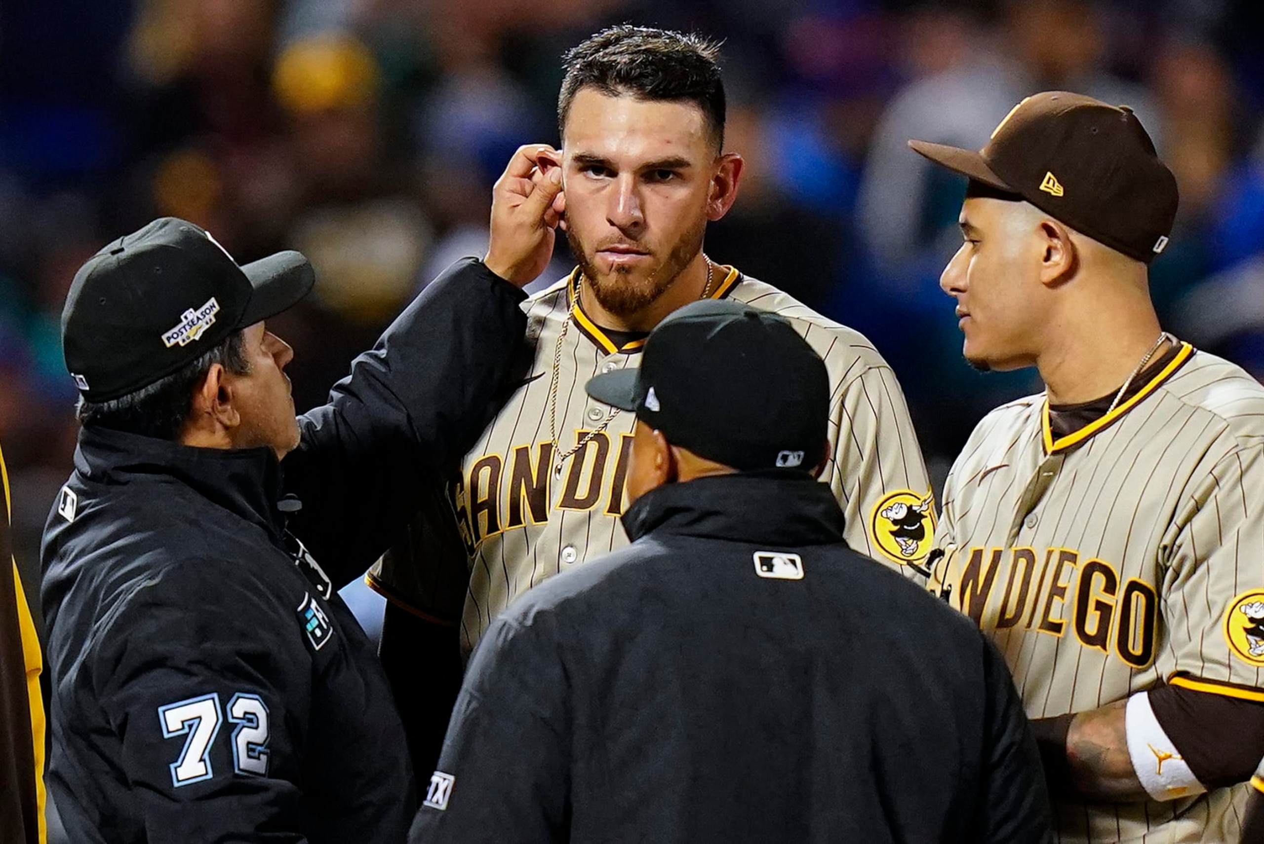 Umpire Alfonso Marquez (72) checks for substances behind the ears of San Diego Padres starting pitcher Joe Musgrove (44) during the sixth inning of Game 3 of a National League wild-card baseball playoff series against the New York Mets, Sunday, Oct. 9, 2022, in New York. (AP Photo/Frank Franklin II)