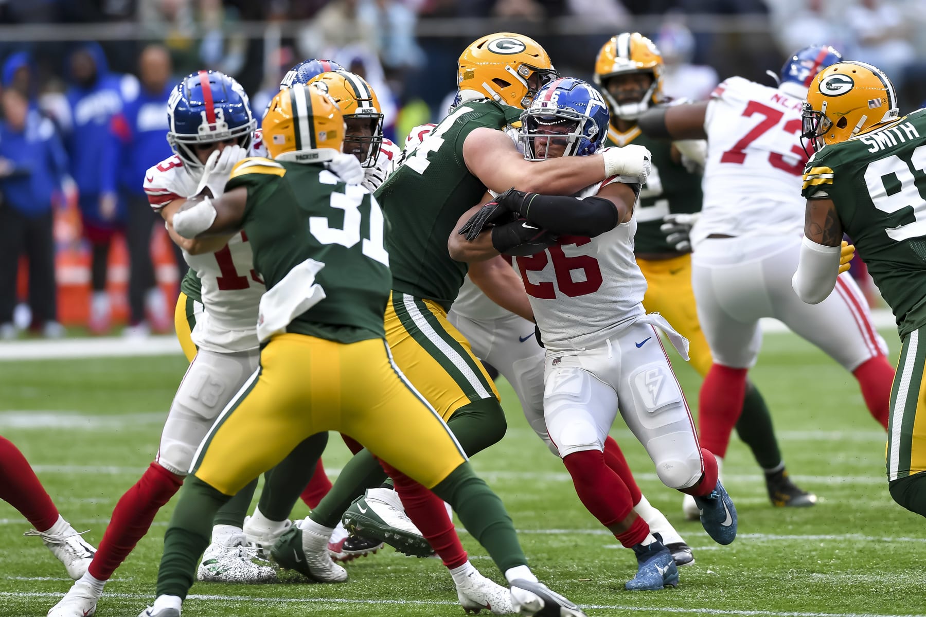 LONDON, ENGLAND - OCTOBER 09: Dean Lowry of Green Bay Packers and Saquon Barkley of New York Giants battle for the ball during the NFL match between New York Giants and Green Bay Packers at Tottenham Hotspur Stadium on October 9, 2022 in London, England. (Photo by Vincent Mignott/DeFodi Images via Getty Images)