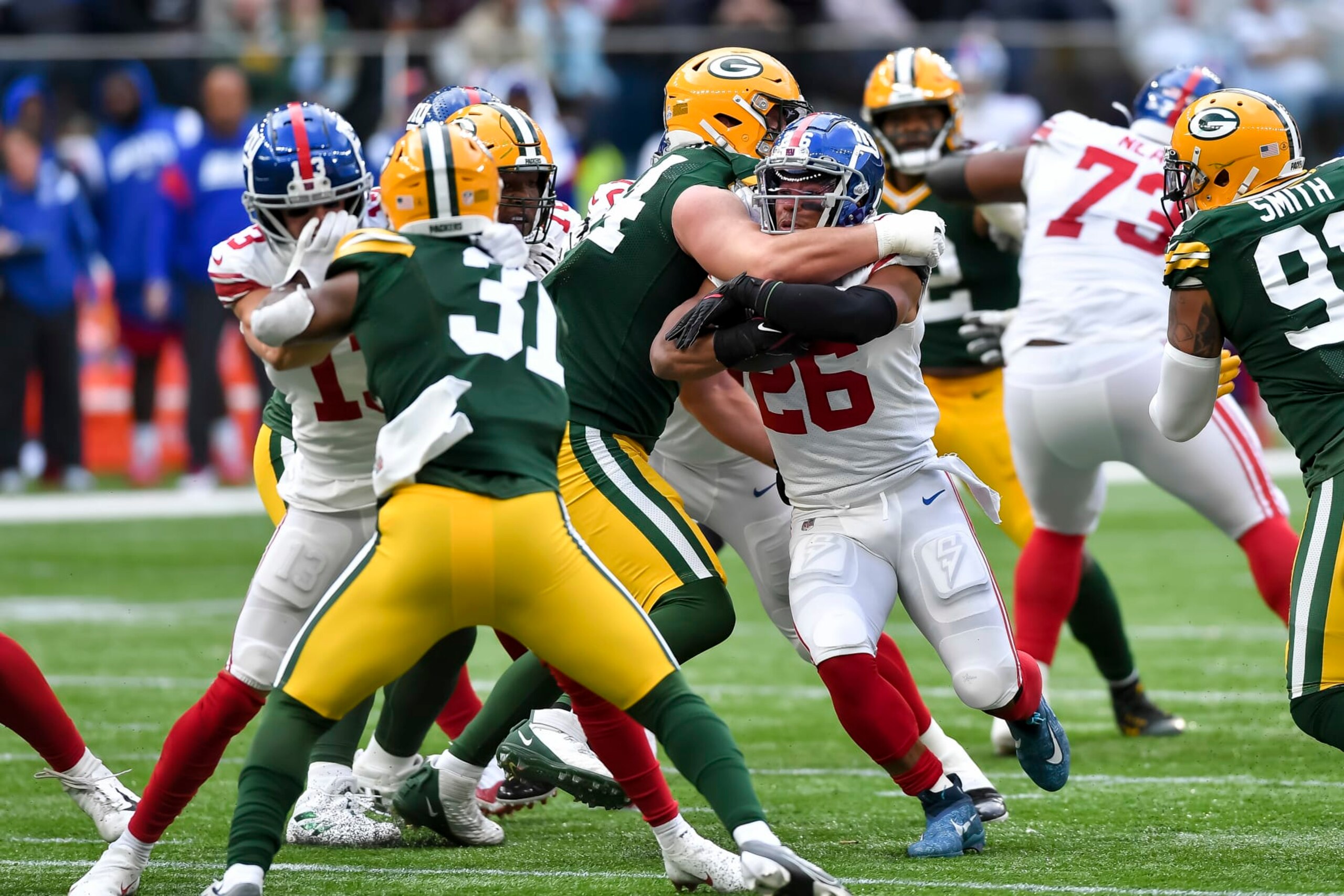 LONDON, ENGLAND - OCTOBER 09: Dean Lowry of Green Bay Packers and Saquon Barkley of New York Giants battle for the ball during the NFL match between New York Giants and Green Bay Packers at Tottenham Hotspur Stadium on October 9, 2022 in London, England. (Photo by Vincent Mignott/DeFodi Images via Getty Images)