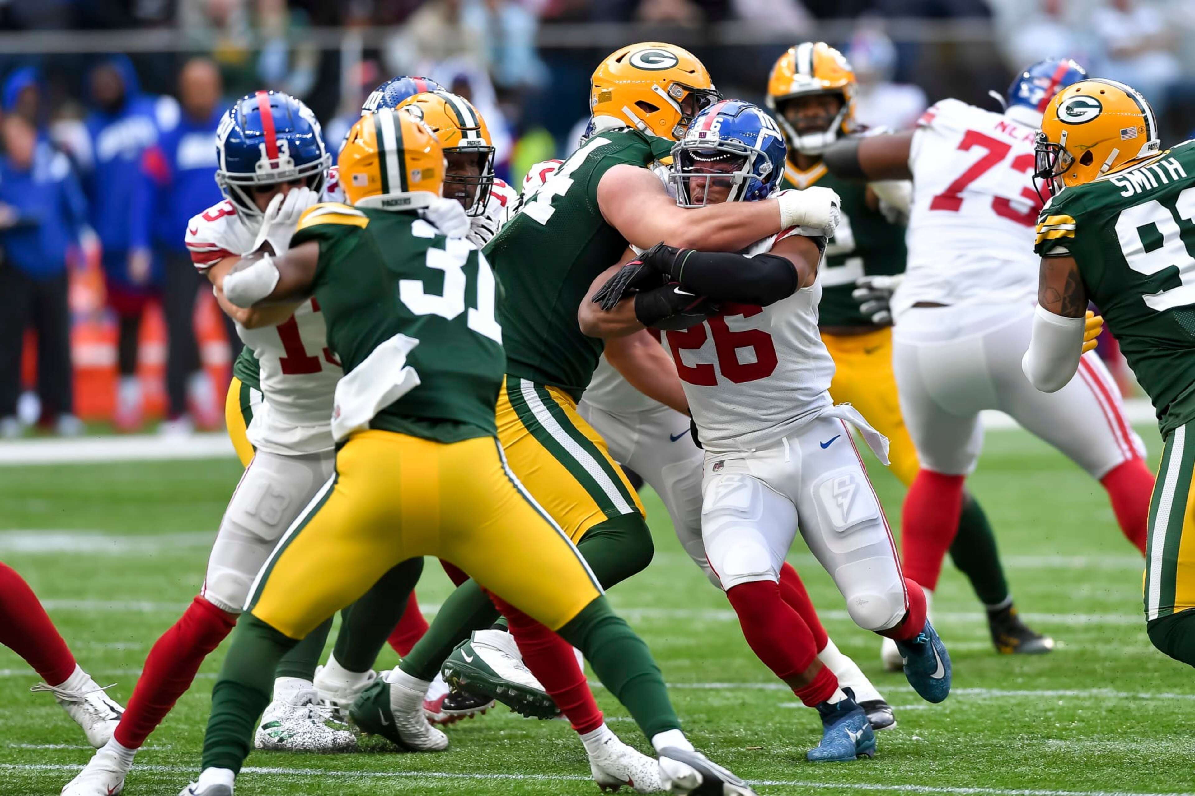 LONDON, ENGLAND - OCTOBER 09: Dean Lowry of Green Bay Packers and Saquon Barkley of New York Giants battle for the ball during the NFL match between New York Giants and Green Bay Packers at Tottenham Hotspur Stadium on October 9, 2022 in London, England. (Photo by Vincent Mignott/DeFodi Images via Getty Images)