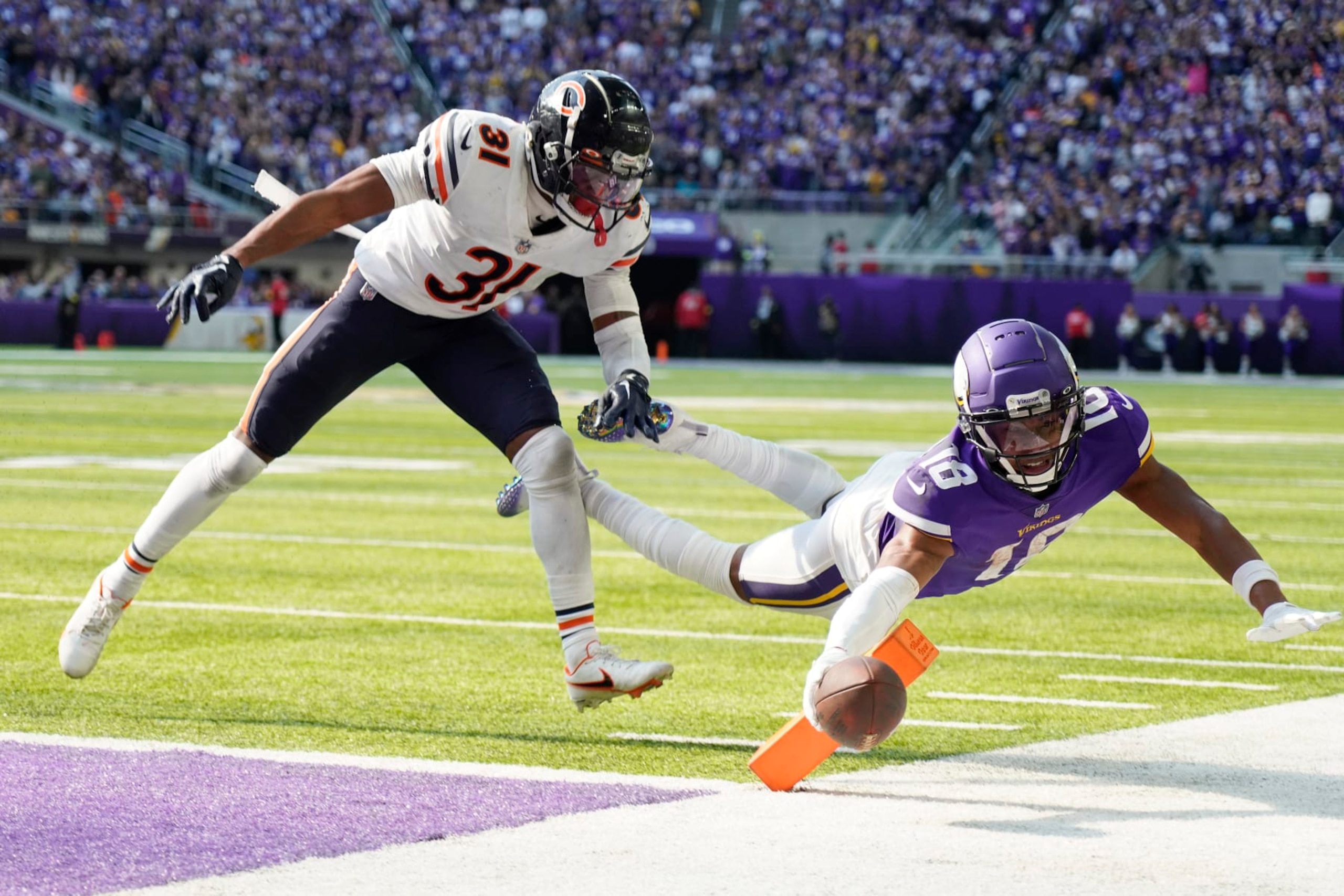 MINNEAPOLIS, MINNESOTA - OCTOBER 09: Justin Jefferson #18 of the Minnesota Vikings dives for a conversion against Jaylon Jones #31 of the Chicago Bears during the fourth quarter at U.S. Bank Stadium on October 09, 2022 in Minneapolis, Minnesota. (Photo by David Berding/Getty Images)
