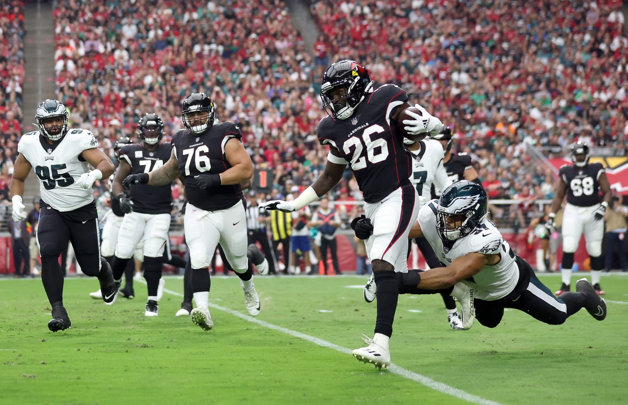 GLENDALE, ARIZONA - OCTOBER 09: Mac McCain III #37 of the Philadelphia Eagles tackles Eno Benjamin #26 of the Arizona Cardinals during the first quarter at State Farm Stadium on October 09, 2022 in Glendale, Arizona. (Photo by Christian Petersen/Getty Images)