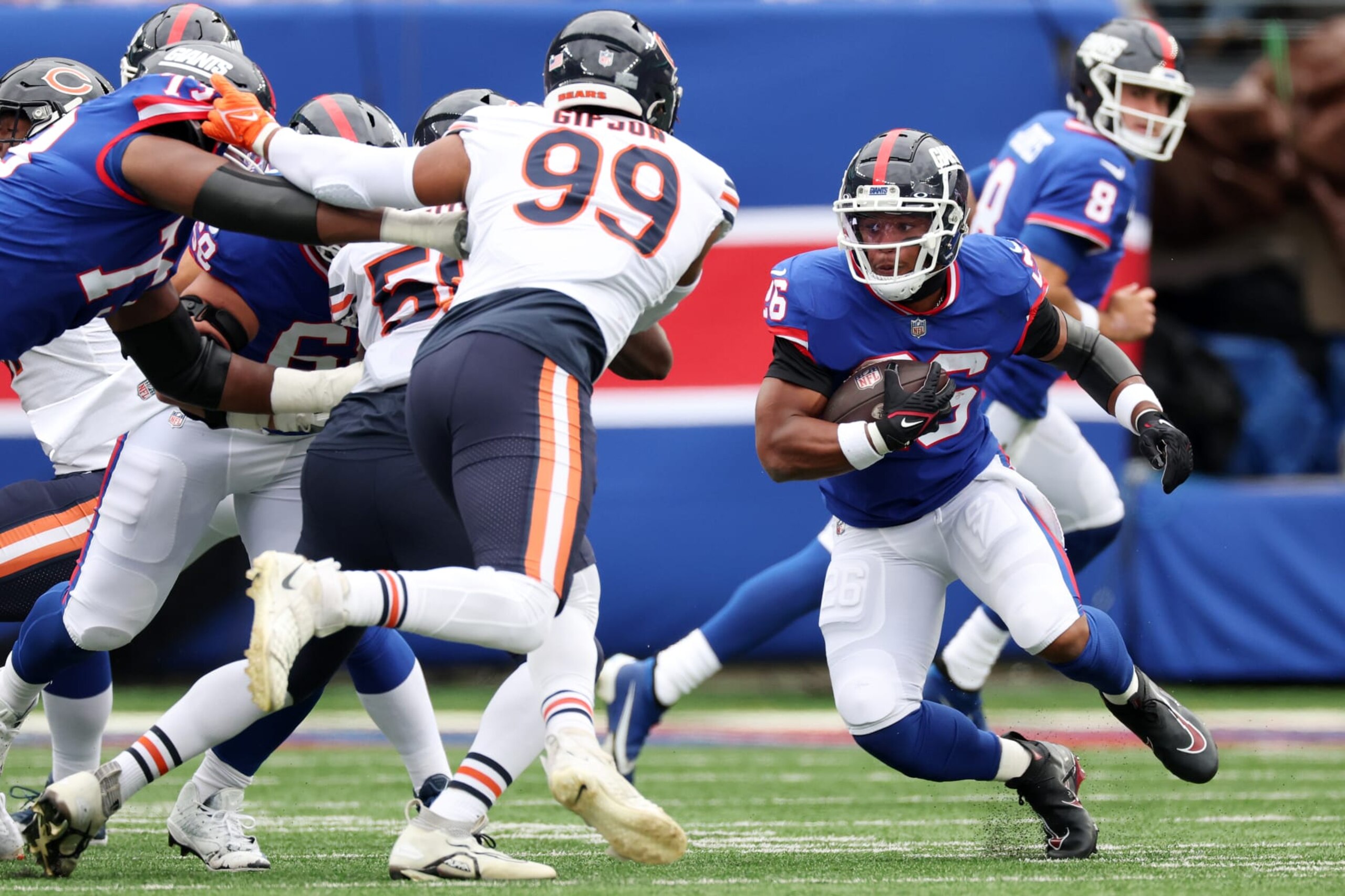 EAST RUTHERFORD, NEW JERSEY - OCTOBER 02: Saquon Barkley #26 of the New York Giants runs with the ball against Trevis Gipson #99 of the Chicago Bears during the second quarter at MetLife Stadium on October 02, 2022 in East Rutherford, New Jersey. (Photo by Al Bello/Getty Images)