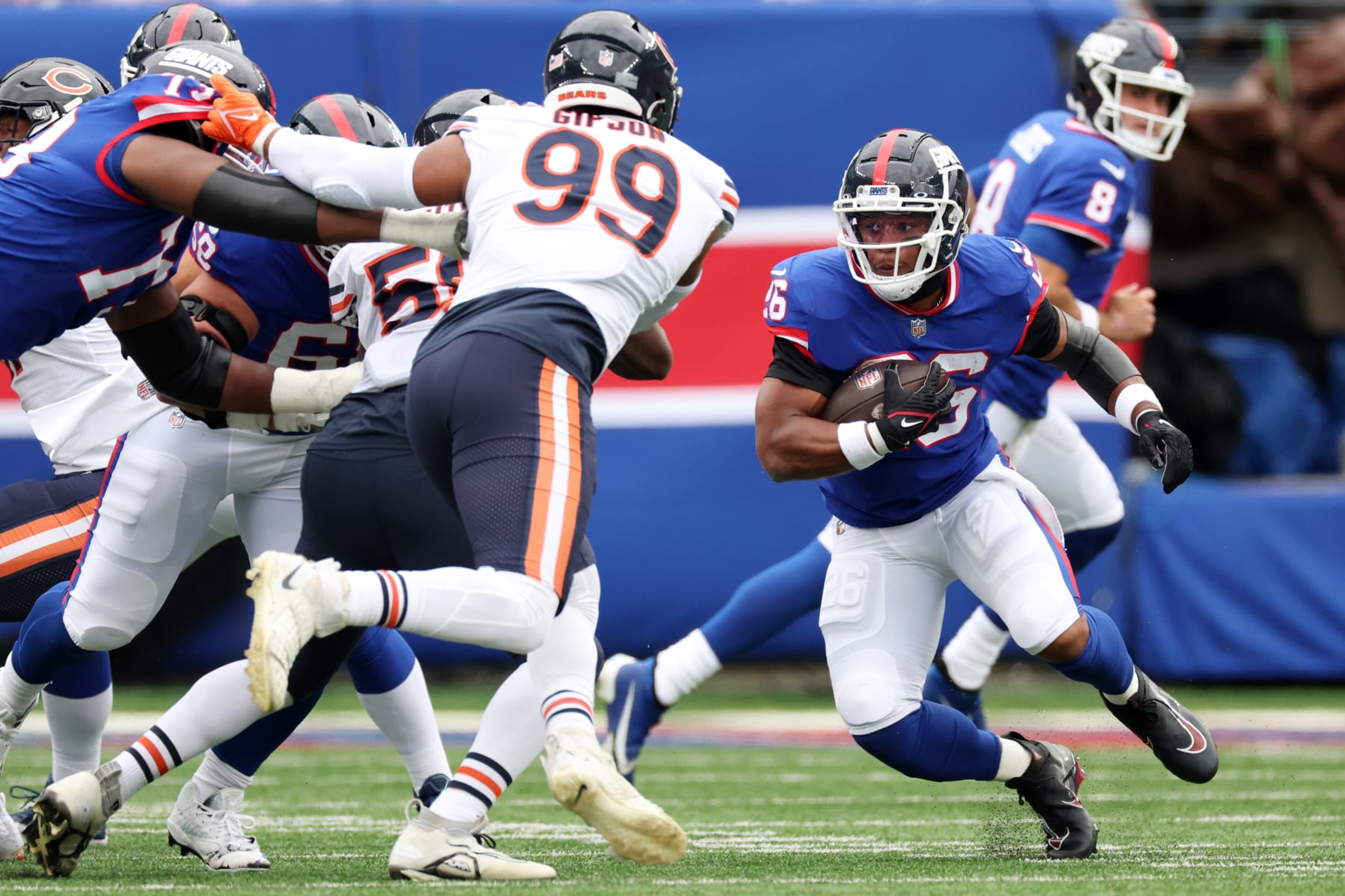 EAST RUTHERFORD, NEW JERSEY - OCTOBER 02: Saquon Barkley #26 of the New York Giants runs with the ball against Trevis Gipson #99 of the Chicago Bears during the second quarter at MetLife Stadium on October 02, 2022 in East Rutherford, New Jersey. (Photo by Al Bello/Getty Images)