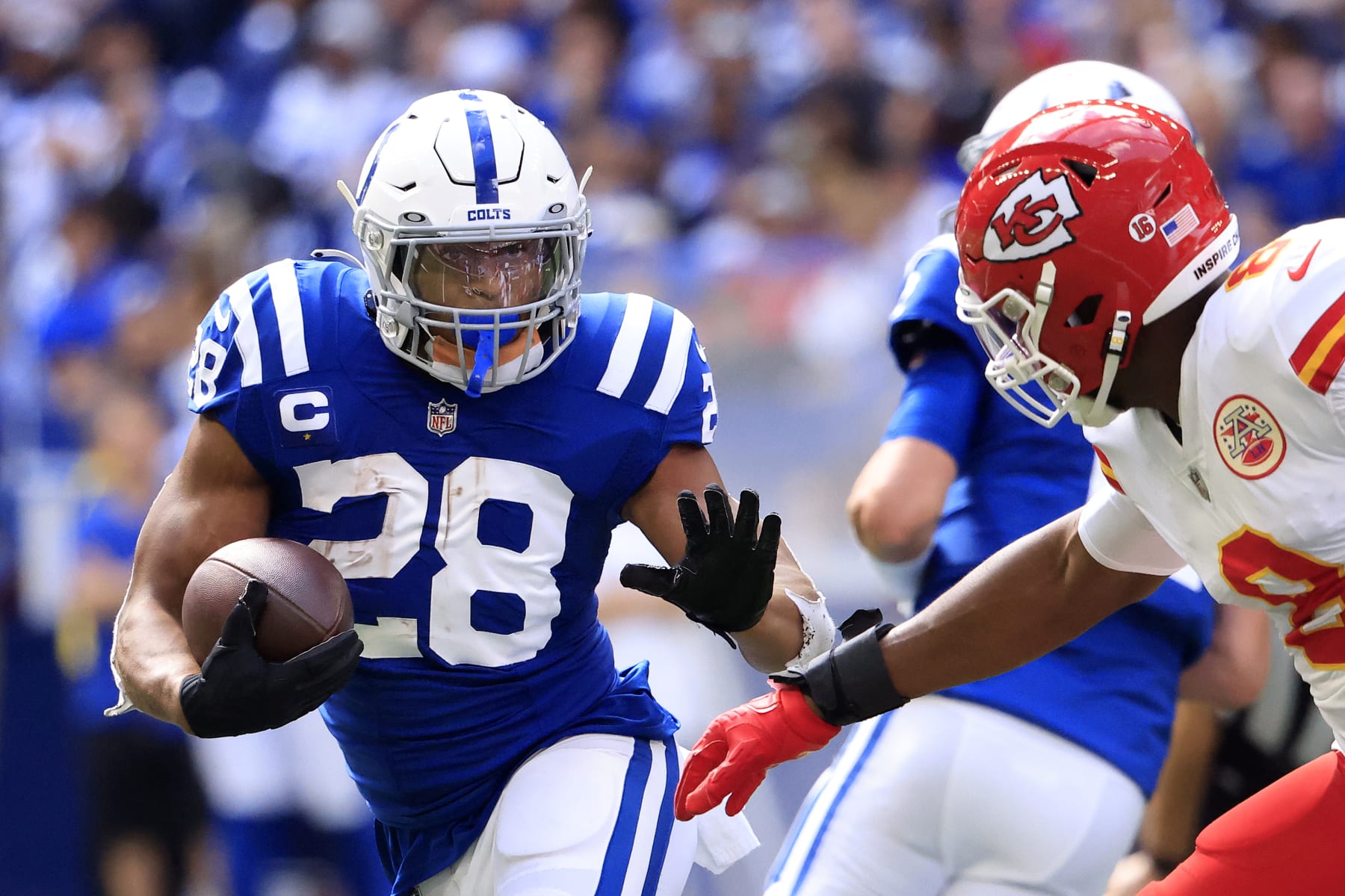 INDIANAPOLIS, INDIANA - SEPTEMBER 25: Jonathan Taylor #28 of the Indianapolis Colts runs with the ball against Carlos Dunlap #8 of the Kansas City Chiefs during the second half at Lucas Oil Stadium on September 25, 2022 in Indianapolis, Indiana. (Photo by Justin Casterline/Getty Images)