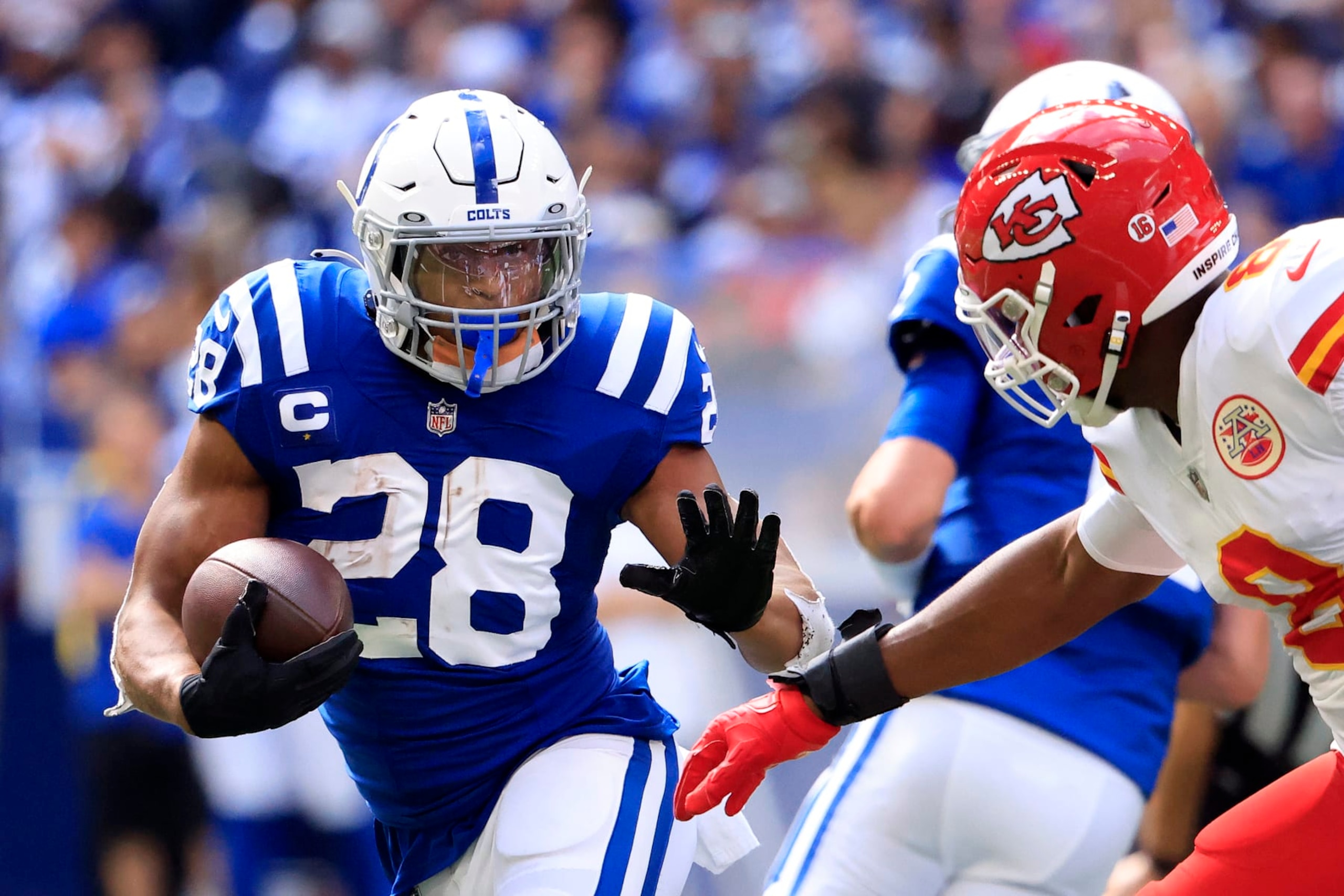 INDIANAPOLIS, INDIANA - SEPTEMBER 25: Jonathan Taylor #28 of the Indianapolis Colts runs with the ball against Carlos Dunlap #8 of the Kansas City Chiefs during the second half at Lucas Oil Stadium on September 25, 2022 in Indianapolis, Indiana. (Photo by Justin Casterline/Getty Images)