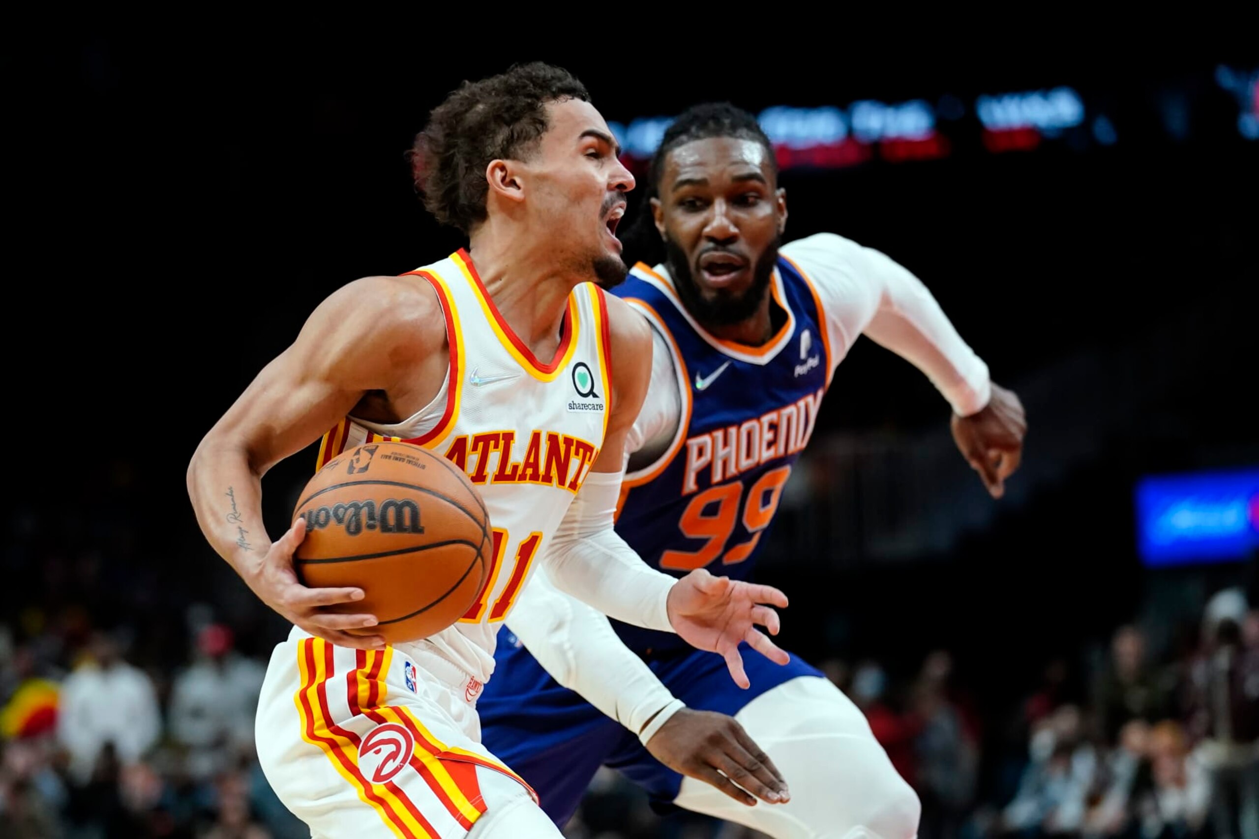Atlanta Hawks guard Trae Young (11) drives past Phoenix Suns forward Jae Crowder (99) during the second half of an NBA basketball game Thursday, Feb. 3, 2022, in Atlanta. (AP Photo/John Bazemore)