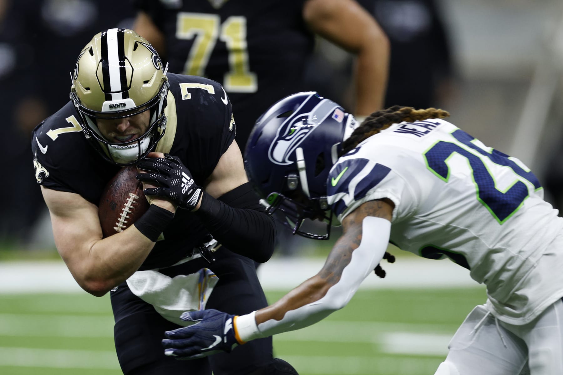 NEW ORLEANS, LOUISIANA - OCTOBER 09: Taysom Hill #7 of the New Orleans Saints is tackled by Ryan Neal #26 of the Seattle Seahawks at Caesars Superdome on October 09, 2022 in New Orleans, Louisiana. (Photo by Chris Graythen/Getty Images)