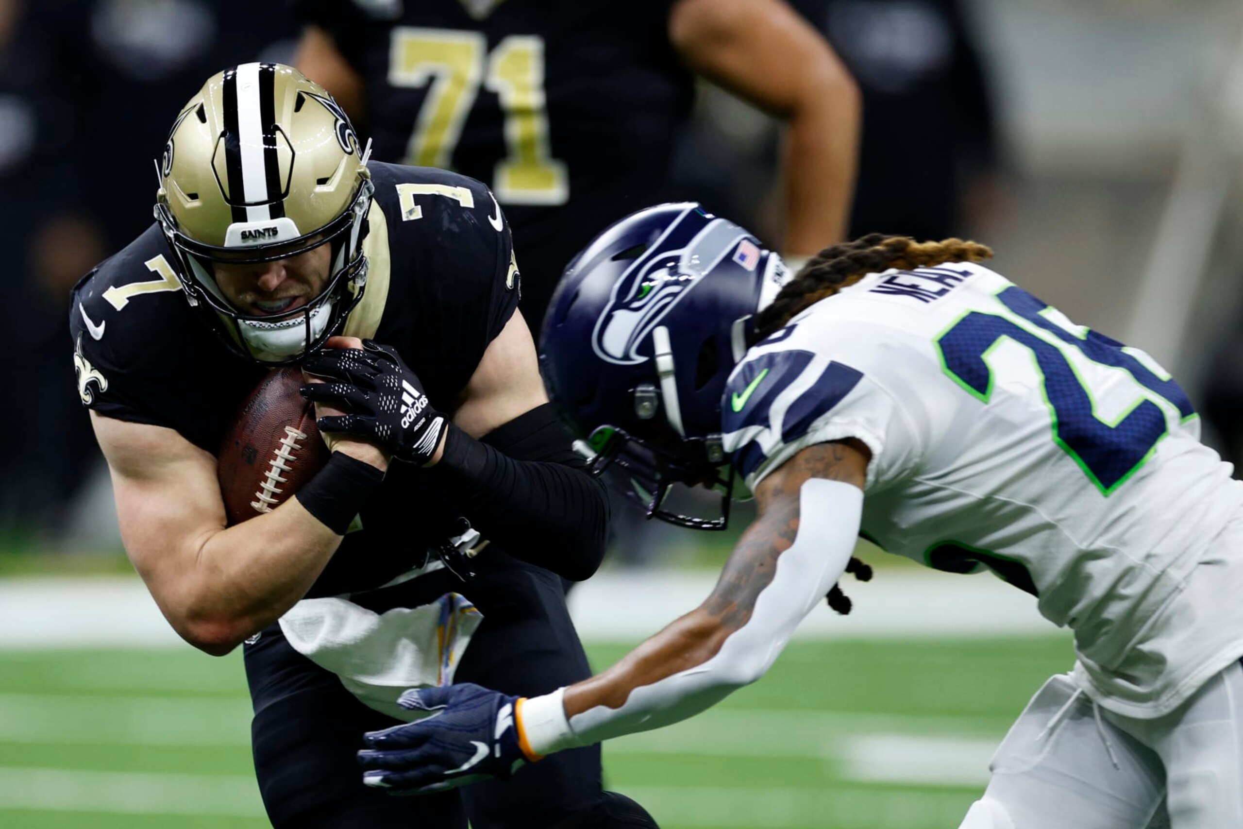 NEW ORLEANS, LOUISIANA - OCTOBER 09: Taysom Hill #7 of the New Orleans Saints is tackled by Ryan Neal #26 of the Seattle Seahawks at Caesars Superdome on October 09, 2022 in New Orleans, Louisiana. (Photo by Chris Graythen/Getty Images)