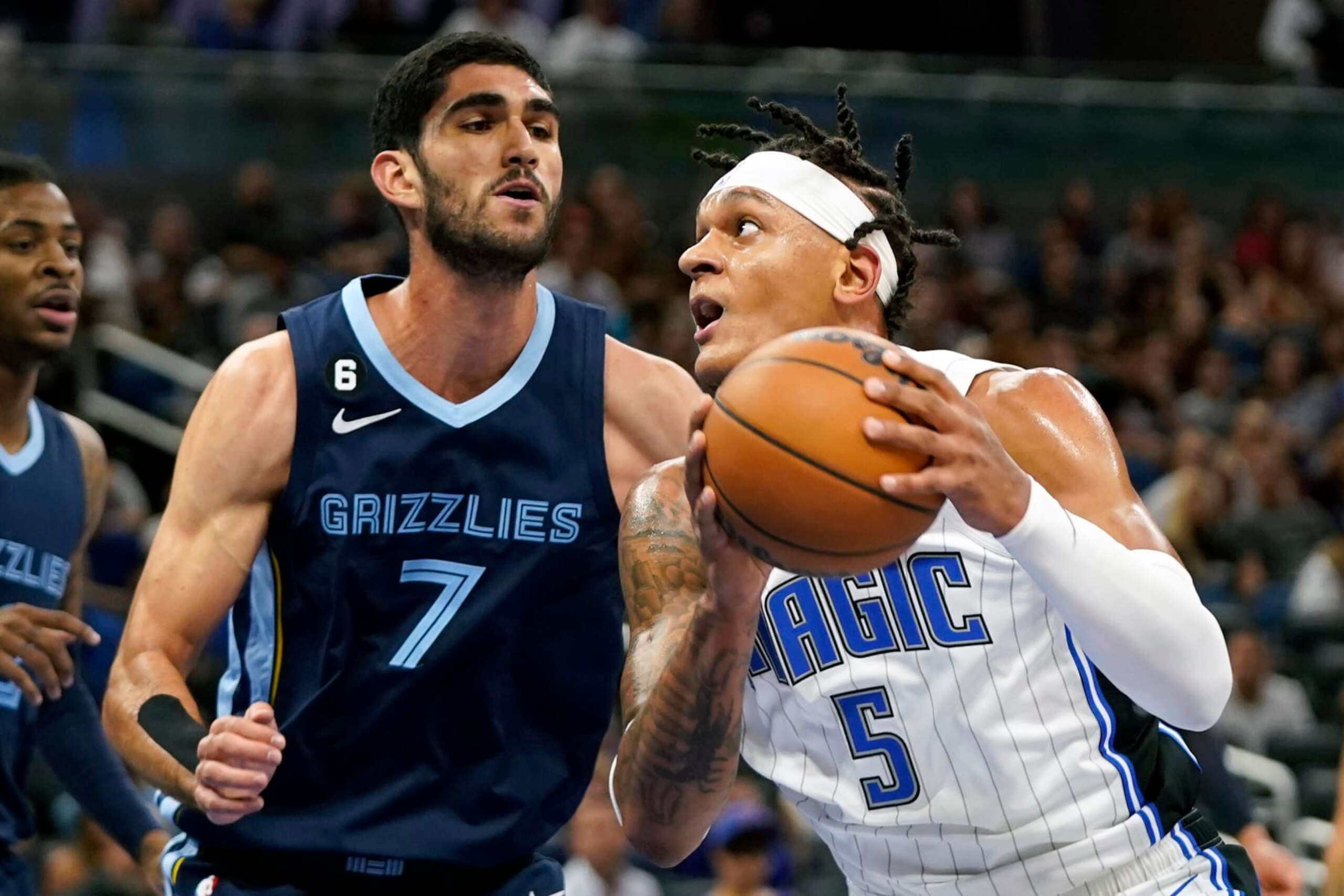 Orlando Magic's Paolo Banchero (5) looks for a shot against Memphis Grizzlies' Santi Aldama (7) during the first half of an NBA preseason basketball game Tuesday, Oct. 11, 2022, in Orlando, Fla. (AP Photo/John Raoux)