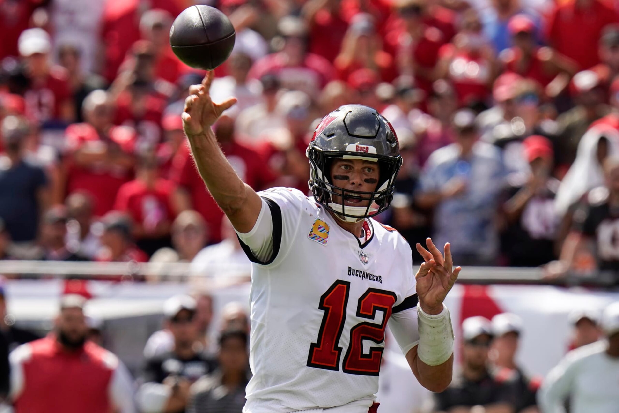 Tampa Bay Buccaneers quarterback Tom Brady (12) throws a touchdown pass to running back Leonard Fournette during the second half of an NFL football game against the Atlanta Falcons Sunday, Oct. 9, 2022, in Tampa, Fla. (AP Photo/Chris O'Meara)