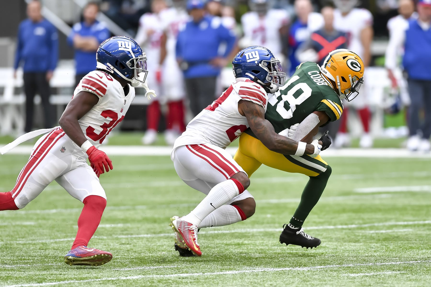 LONDON, ENGLAND - OCTOBER 09: Darnay Holmes of New York Giants, Xavier McKinney of New York Giants and Randall Cobb of Green Bay Packers with a tackle during battle for the ball during the NFL match between New York Giants and Green Bay Packers at Tottenham Hotspur Stadium on October 9, 2022 in London, England. (Photo by Vincent Mignott/DeFodi Images via Getty Images)
