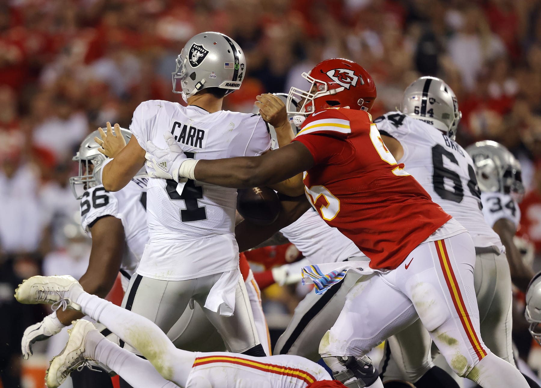 KANSAS CITY, MISSOURI - OCTOBER 10:  Derek Carr #4 of the Las Vegas Raiders is sacked by Chris Jones #95 of the Kansas City Chiefs during the 2nd quarter of the game at Arrowhead Stadium on October 10, 2022 in Kansas City, Missouri. Jones was called for a penalty for roughing the passer. (Photo by David Eulitt/Getty Images)