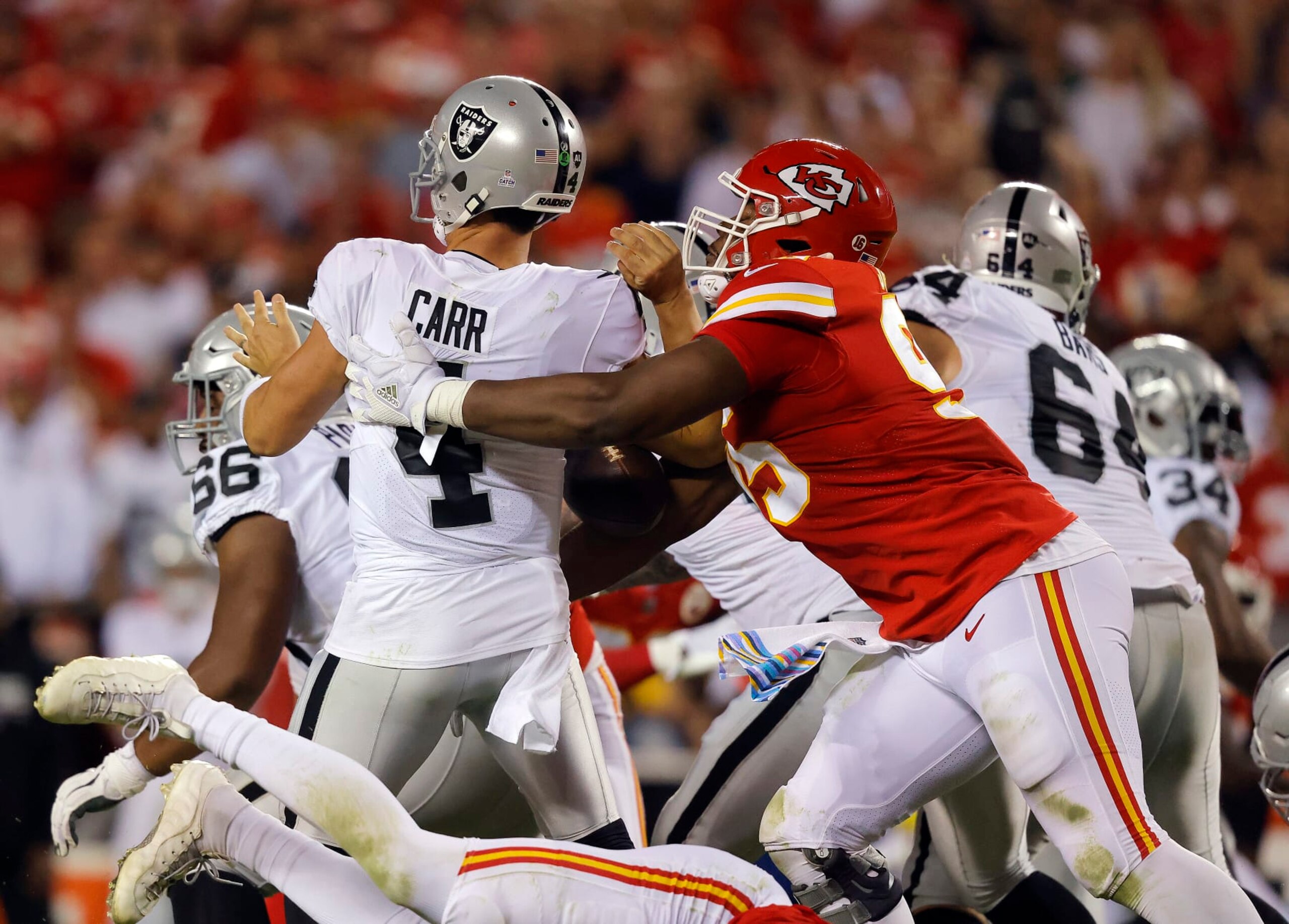 KANSAS CITY, MISSOURI - OCTOBER 10:  Derek Carr #4 of the Las Vegas Raiders is sacked by Chris Jones #95 of the Kansas City Chiefs during the 2nd quarter of the game at Arrowhead Stadium on October 10, 2022 in Kansas City, Missouri. Jones was called for a penalty for roughing the passer. (Photo by David Eulitt/Getty Images)