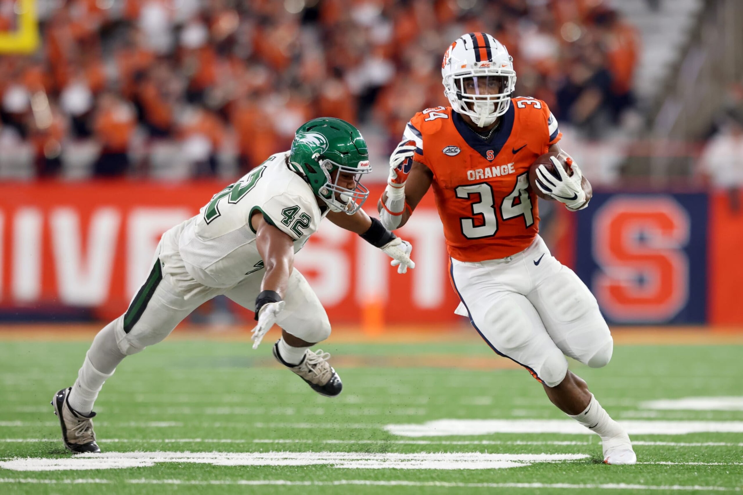 SYRACUSE, NEW YORK - OCTOBER 01: Junior Wily #42 of the Wagner Seahawks attempts to tackle Sean Tucker #34 of the Syracuse Orange during the second quarter at JMA Wireless Dome on October 01, 2022 in Syracuse, New York. (Photo by Bryan M. Bennett/Getty Images)