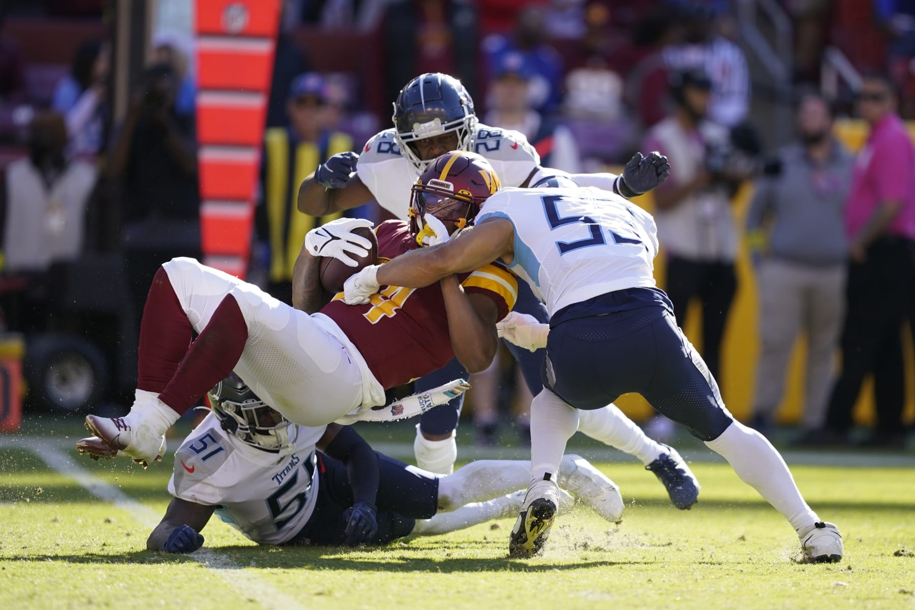 Washington Commanders running back Antonio Gibson is tackled by Tennessee Titans defenders in the second half of an NFL football game, Sunday, Oct. 9, 2022, in Landover, Md. (AP Photo/Alex Brandon)