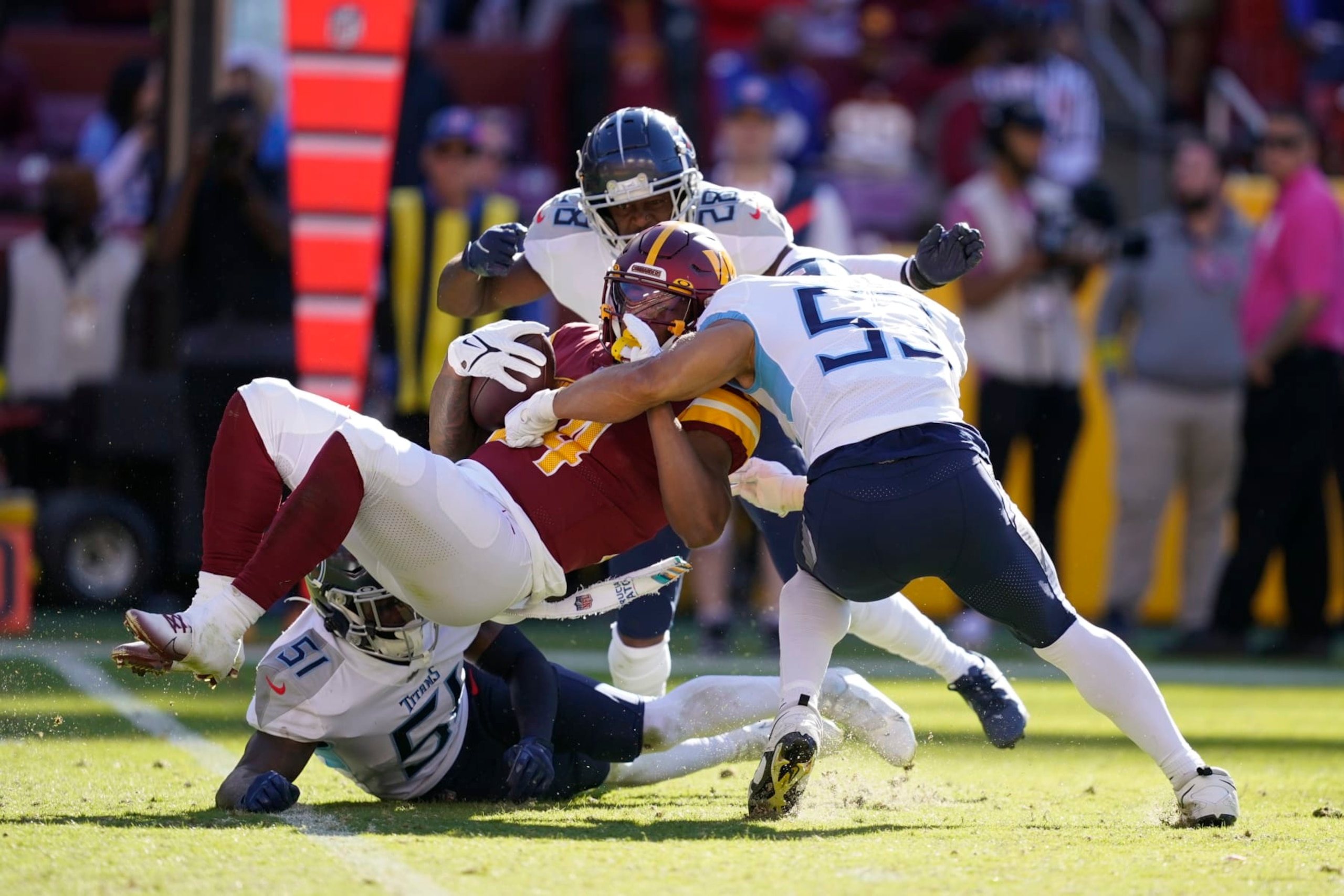 Washington Commanders running back Antonio Gibson is tackled by Tennessee Titans defenders in the second half of an NFL football game, Sunday, Oct. 9, 2022, in Landover, Md. (AP Photo/Alex Brandon)